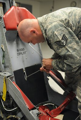 Staff Sgt. Louie Bennett, 2nd Maintenance Squadron accessories flight aircrew egress technician, inspects an ejection seat upper harness attachment cable for abrasions and cuts on Barksdale Air Force Base, La., June 26. The cable is used to pull aircrew members back into their seats as they eject from an aircraft. (U.S. Air Force photo/Airman 1st Class Benjamin Gonsier)(RELEASED)

