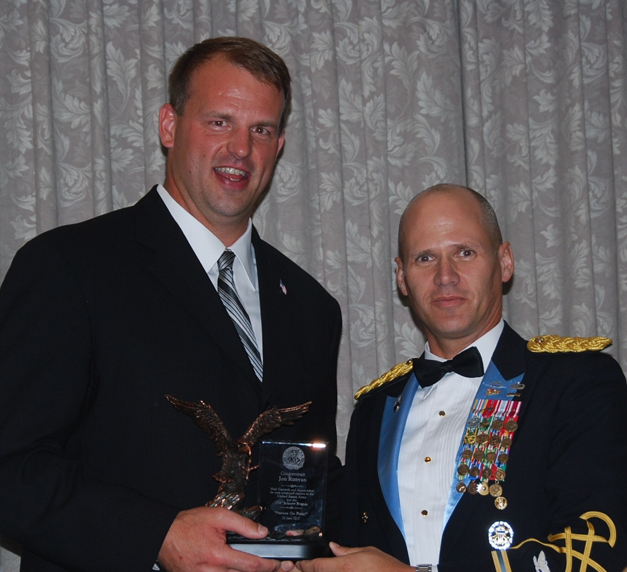 Col. Craig A. Osborne, commander, 174th Infantry Brigade, presents Congressman Jon Runyan with a symbol of patriotism in honor of his service and attendance. (Photo by Army Capt. Antonia Greene/Released)