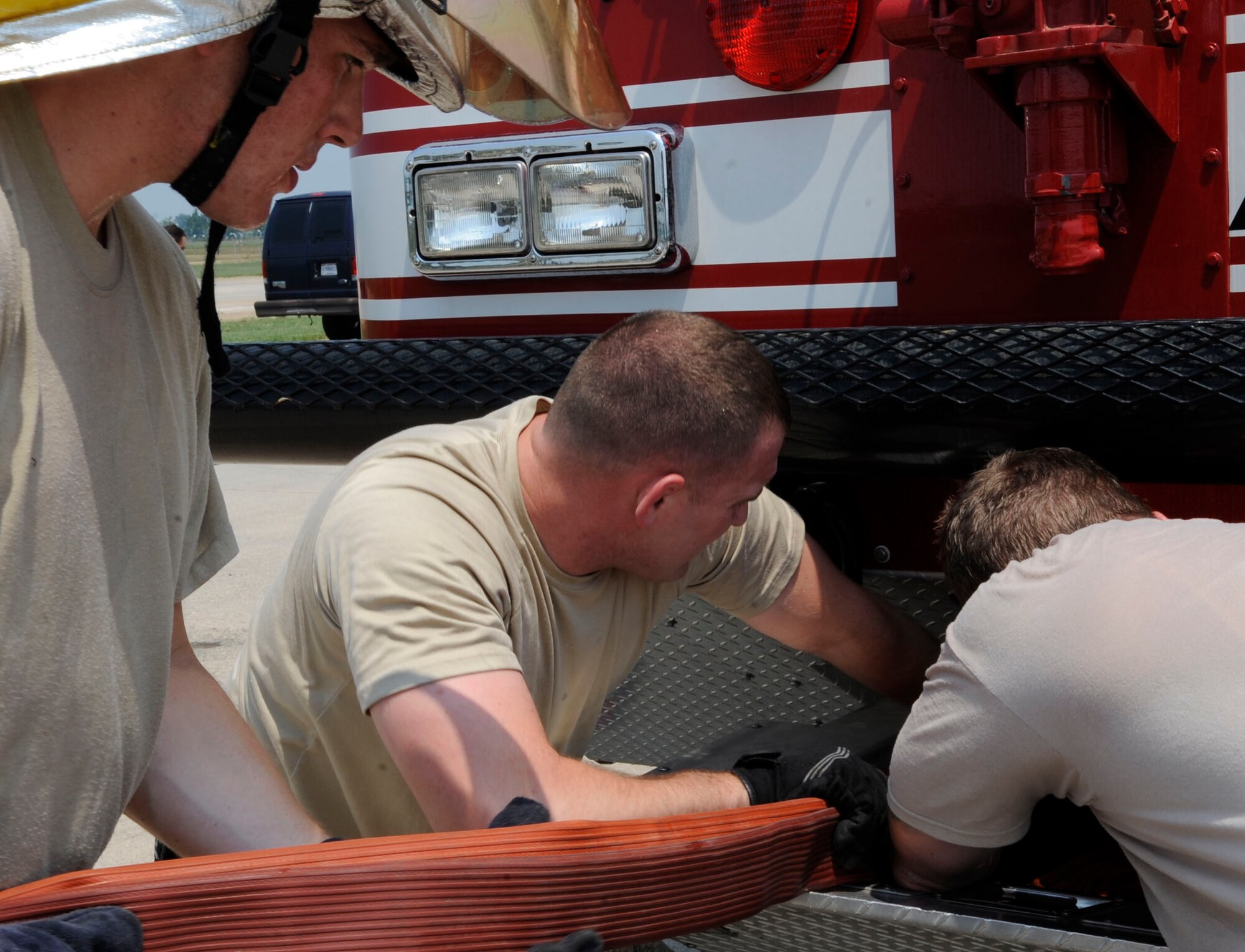 Firefighters from the 2nd Civil Engineer Squadron put fire hoses back into the fire truck on Barksdale Air Force Base, La. June 26. The firefighters responded to a simulated fire with possible strategic assets present as part of a Nuclear Surety Exercise. (U.S. Air Force photo/Airman 1st Class Joseph A. Pagán Jr.)(RELEASED)
