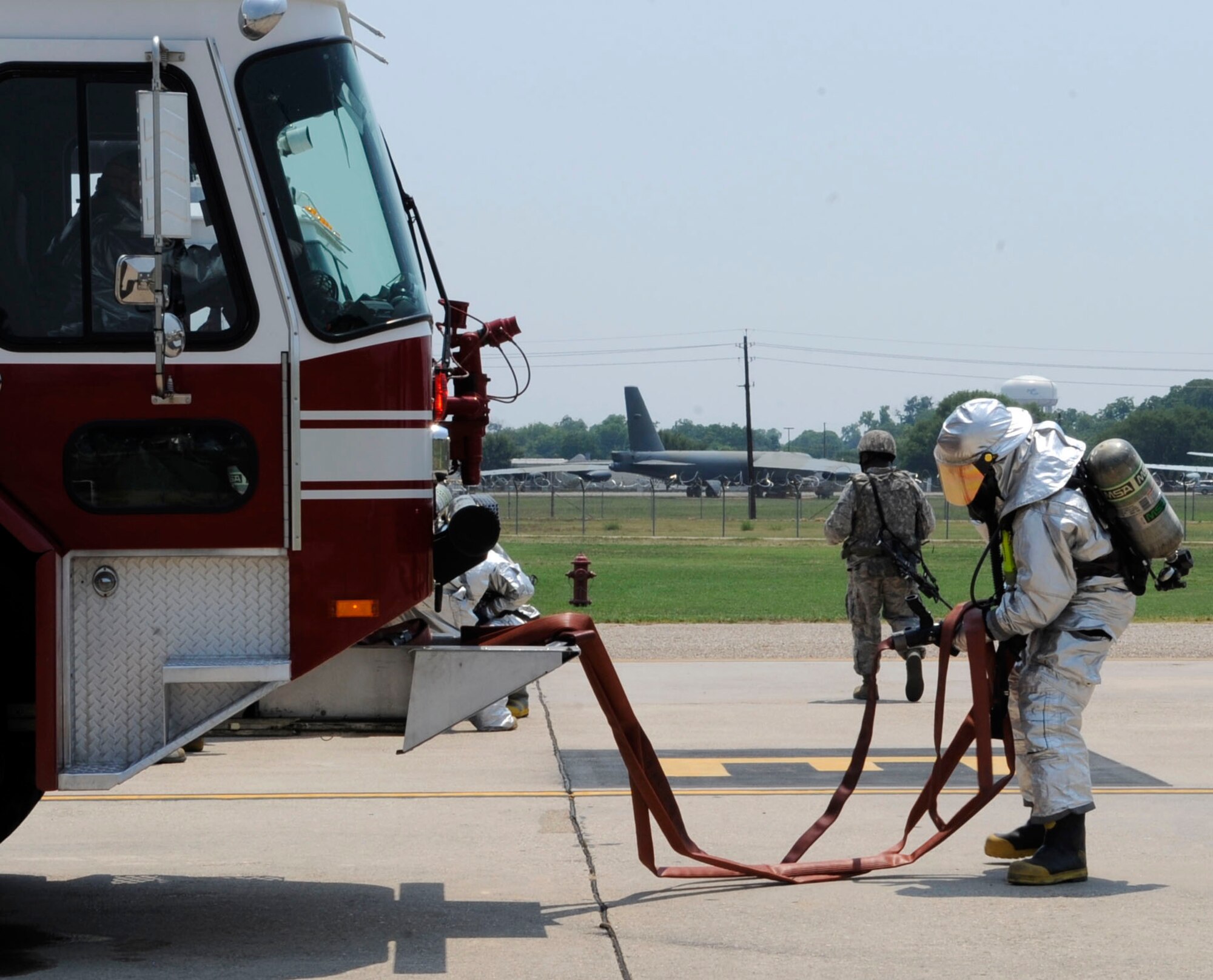 A firefighter from the 2nd Civil Engineer Squadron removes water hoses from a fire truck on Barksdale Air Force Base, La., June 26. The hose was used to extinguish a simulated fire on a B-52H Stratofortress during a Nuclear Surety Exercise. The NSE ensures firefighters are prepared to accomplish the mission in the presence of strategic assets. (U.S. Air Force photo/Airman 1st Class Joseph A. Pagán Jr.)(RELEASED)