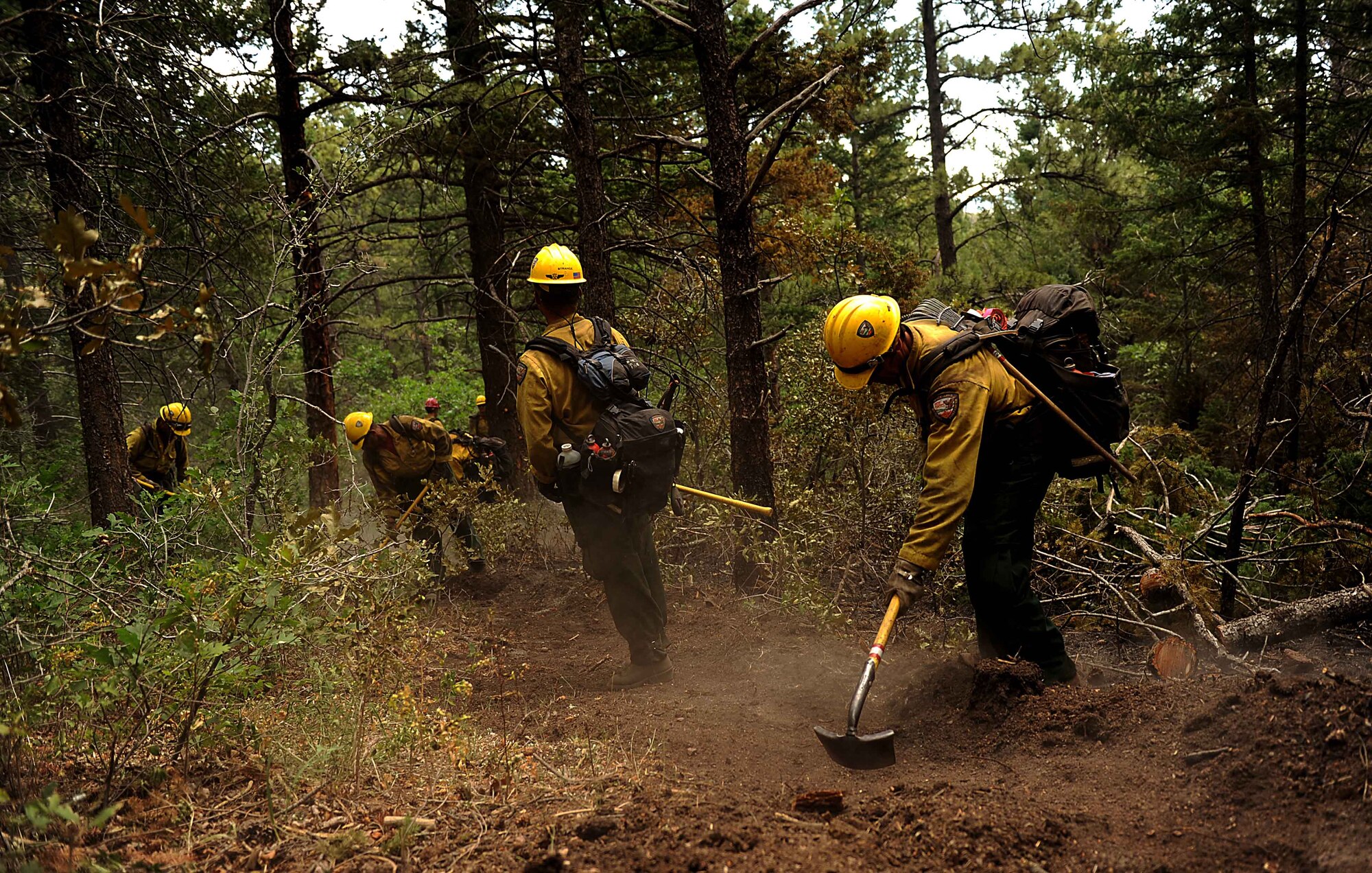 Firefighters from the Vandenberg Air Force Base, Calif., Hot Shots cut a fire line in the Mount Saint Francois area of Colorado Springs, Colo., while helping to battle several fires in Waldo Canyon on June 28, 2012.  The Waldo Canyon fire has grown to 18,500 acres and burned more than 300 homes. (U.S. Air Force photo/Master Sgt. Jeremy Lock)