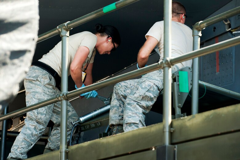 U.S. Air Force Staff Sgt. Matthew Bailey watches as Senior Airman Erin Bernik uses a grease gun to actuate the attachment pins of an Air Launched Cruise Missile Pylon during a weapons loading operation, Barksdale Air Force Base, La., June 15, 2012. Bailey and Bernik are weapons loaders assigned to the 707th Maintenance Squadron and members of the first load crew in the Air Force Reserve Command certified to load nuclear weapons on a B-52. (U.S. Air Force photo by Master Sgt. Greg Steele/Released)