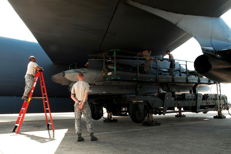 U.S. Air Force Staff Sgt. Joe San Agustin and Tech. Sgt. Thomas Richey, 2nd Maintenance Group Loading Standardization Crew members, evaluate an Air Force Reserve Command weapons load crew as they upload an Air Launched Cruise Missile Pylon onto the wing of a B-52H Stratofortress, Barksdale Air Force Base, La., June 15, 2012. The AFRC load crew is assigned to the 707th Maintenance Squadron is the first ever certified to load nuclear weapons on a B-52. (U.S. Air Force photo by Master Sgt. Greg Steele/Released)