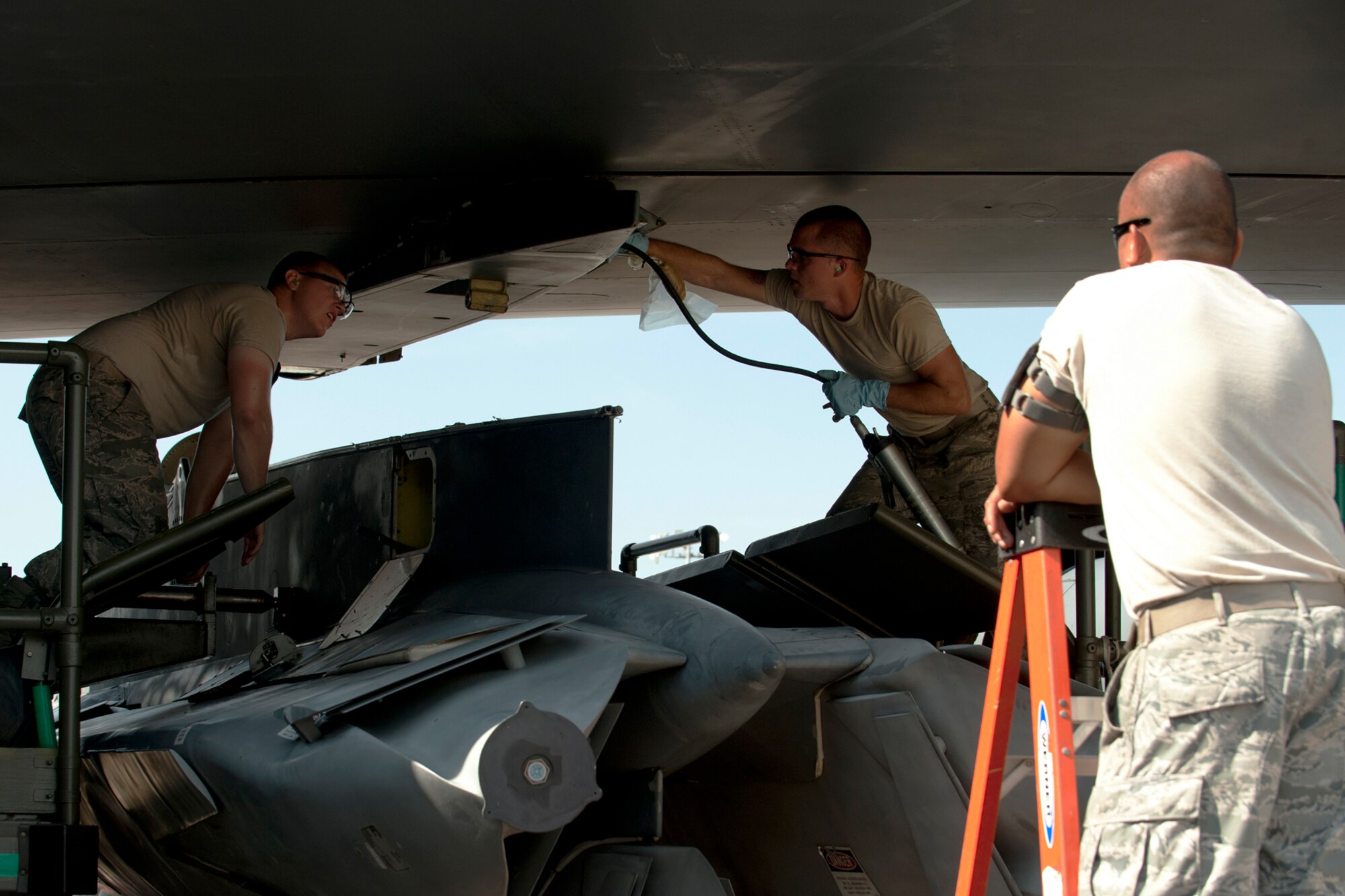 Under the watchful eye of an evaluator, U.S. Air Force Tech. Sgt. Donald Ballard looks on as Staff Sgt. Matthew Bailey prepares a wing attachment point for the installation of an Air Launched Cruise Missile Pylon during a weapons loading operation, Barksdale Air Force Base, La., June 15, 2012. Ballard and Bailey are assigned to the 707th Maintenance Squadron and are members of the first load crew in the Air Force Reserve Command certified to load nuclear weapons on a B-52. (U.S. Air Force photo by Master Sgt. Greg Steele/Released)