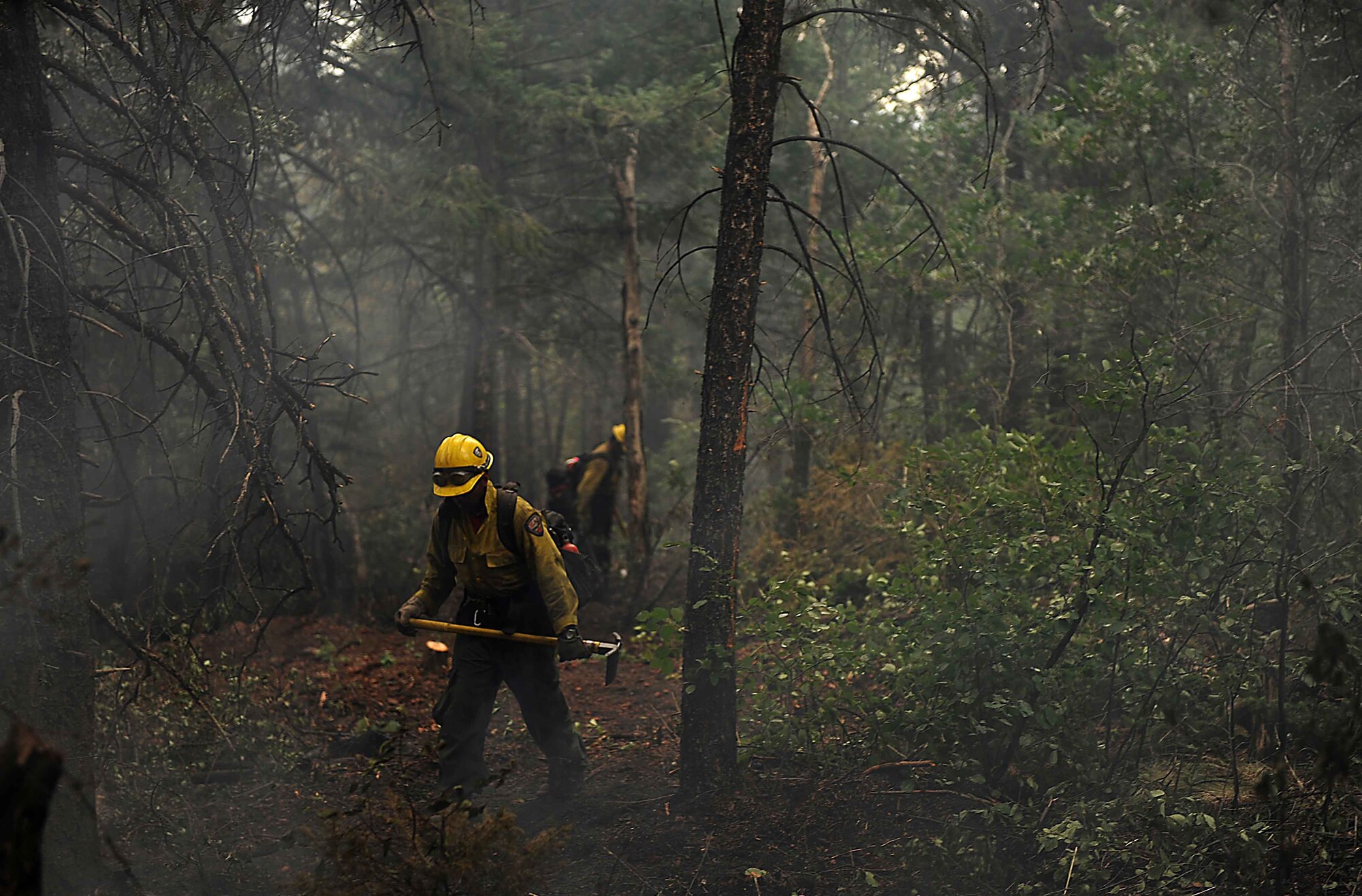 Lupe Covarrubias cuts a fire line in the Mount Saint Francois area of Colorado Springs, Colo., while helping to battle several fires in Waldo Canyon on June 28, 2012. The Waldo Canyon fire has grown to 18,500 acres and burned more than 300 homes. Covarrubias is a firefighter with the Vandenberg Air Force Base, Calif., Hot Shots. (U.S. Air Force photo/Master Sgt. Jeremy Lock)