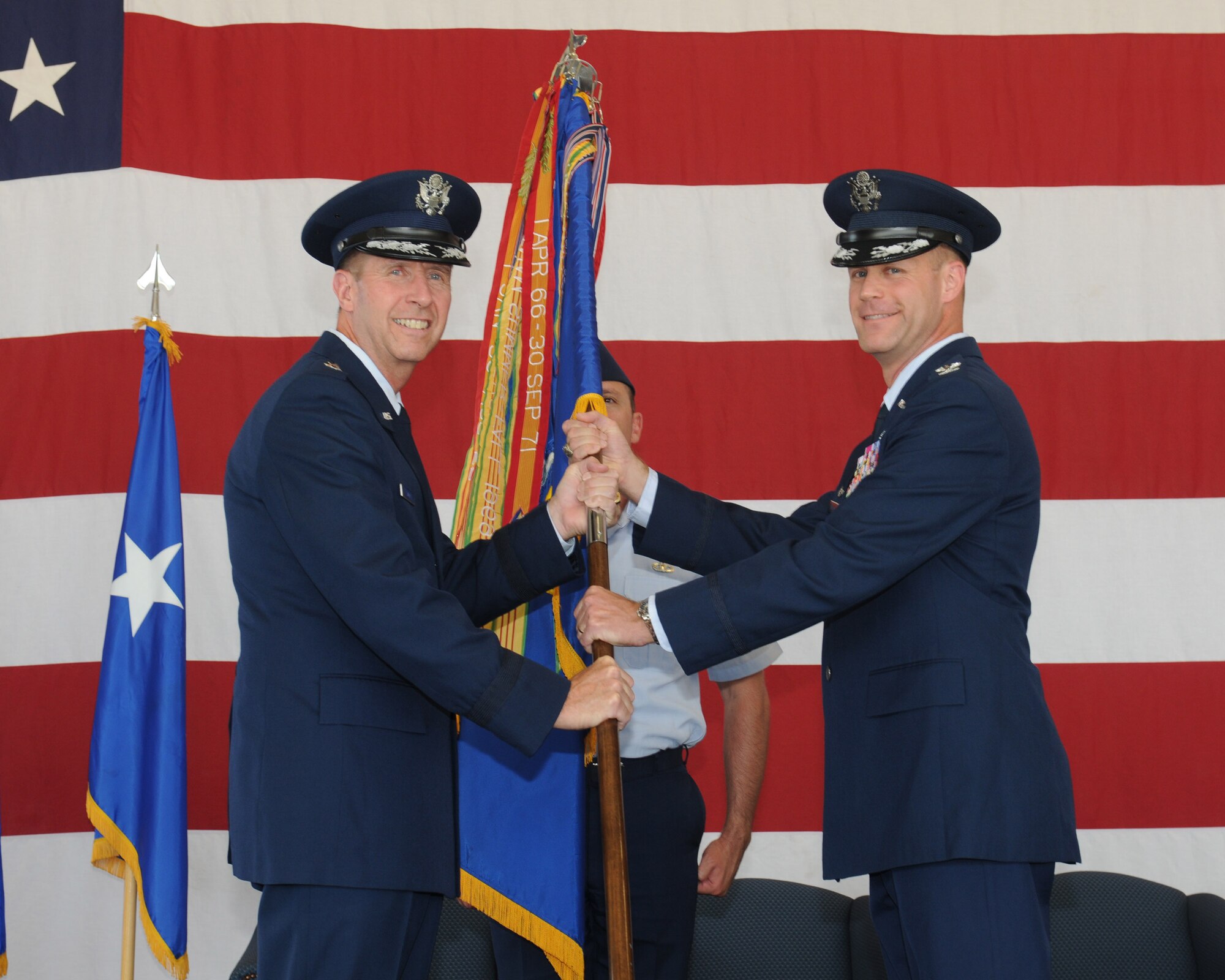 Maj. Gen. Mark Solo, 19th Air Force Commander passes the 14th Flying Training Wing guidon to Col. Jim Sears, 14th FTW Commander during a change of commander ceremony on June 28 at the aircraft fuel maintenance hangar. The passing of the guidon symbolizes the transfer of command from one individual to another. (U.S. Air Force photo)