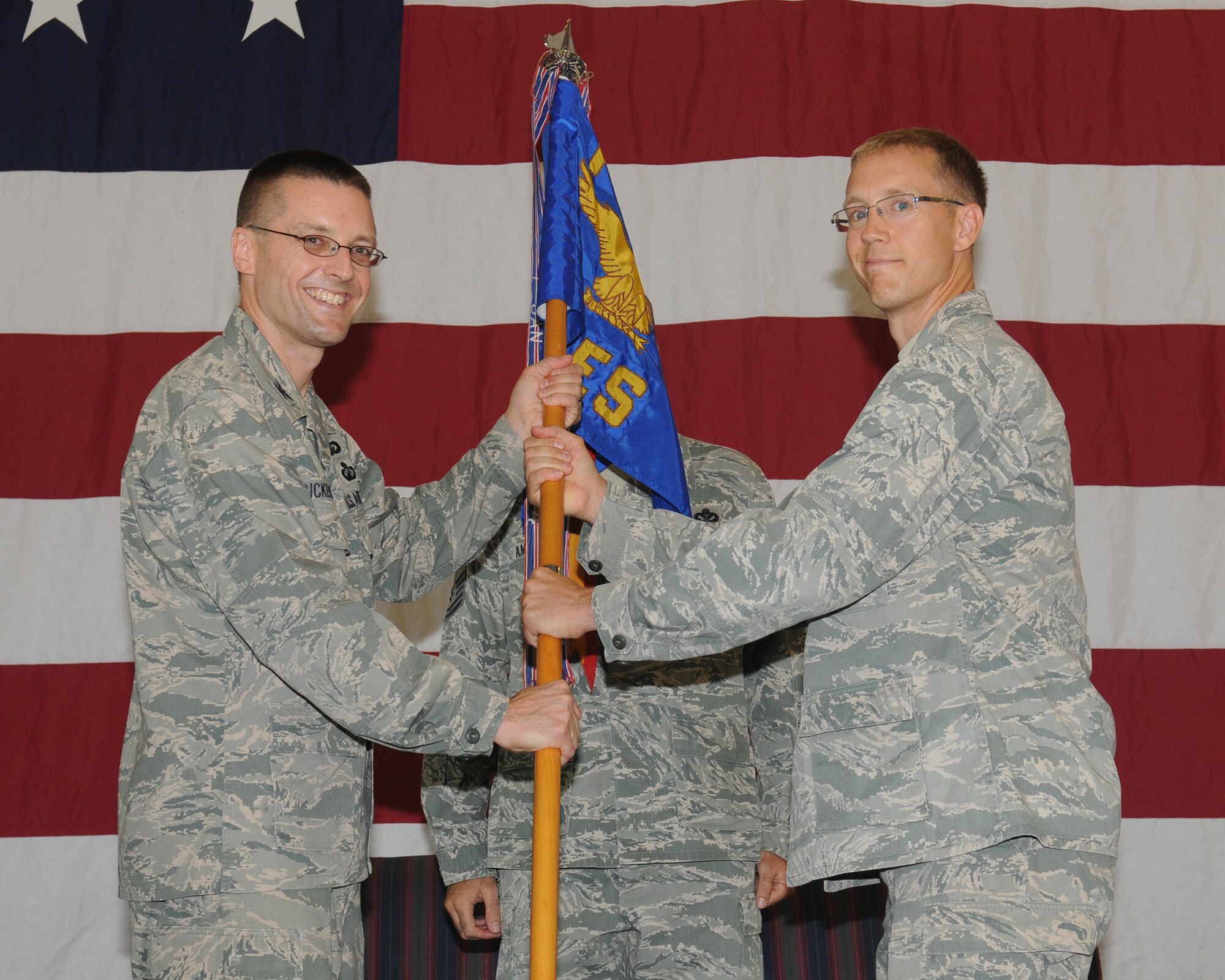 Col. Scott Frickenstein, 14th Mission Support Group Commander passes the 14th Civil Engineer Squadron guidon to Lt. Col. David Meissen, 14th CES Commander during an assumption of command ceremony on June 22. (U.S. Air Force photo/Melissa Doublin)
