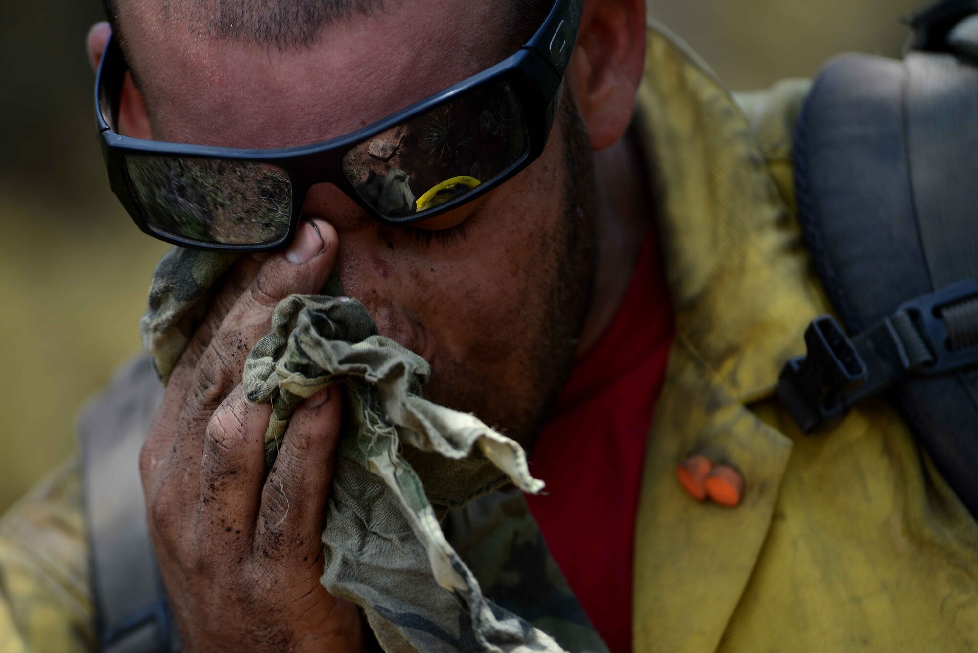 Chris Loung wipes sweat from his face while cutting a fire line in the Mount Saint Francois area of Colorado Springs, Colo., June 28, 2012. The Waldo Canyon fire has grown to 18,500 acres and burned more than 300 homes. Loung is a firefighter with the Vandenberg Air Force Base, Calif., Hot Shots. (U.S. Air Force photo/Master Sgt. Jeremy Lock)