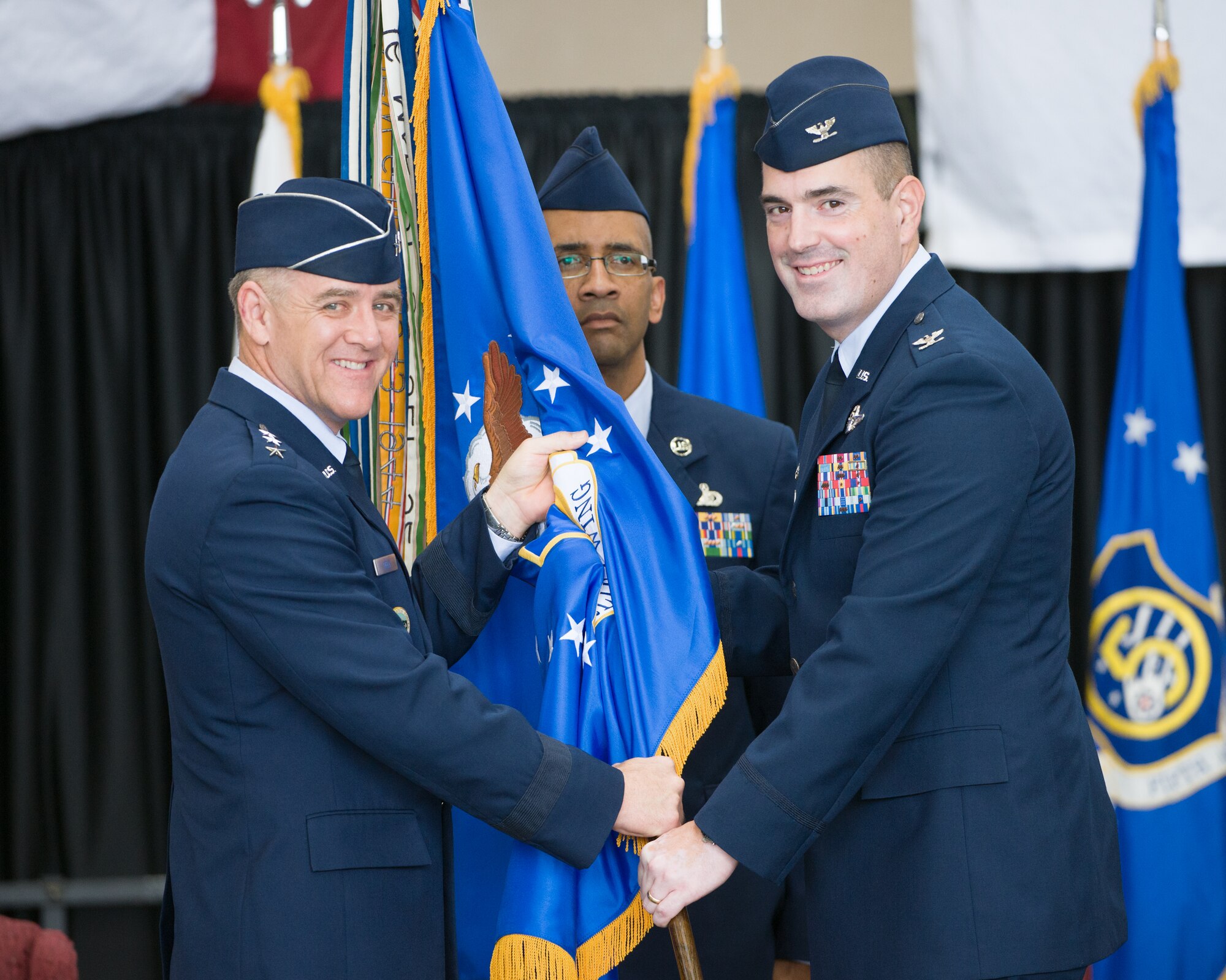 YOKOTA AIR BASE, Japan -- Lt. Gen. Burton Field, 5th Air Force and U.S. Forces, Japan, commander, passes the wing guidon to the new 374th Airlift Wing Commander Col. Mark R. August during a change of command ceremony at Yokota Air Base, Japan, June 29, 2012. The ancient ceremony traces its roots to medieval battlefields where the knights were obliged to obey the orders of the warrior carrying their unit guidon. (U.S. Air Force photo by Staff Sgt. Shawn Rhodes)