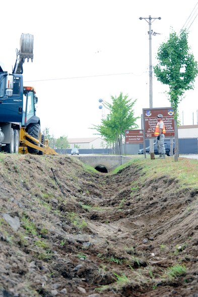 Staff Sgt. Jacob Membreno, 8th Civil Engineer Squadron pavements and heavy equipment journeyman, directs a fellow “Dirt Boy” as they clean drainage ditches June 28, 2012, Kunsan Air Base, Republic of Korea. Monsoon season is a period of intense rainfall; digging ditches gives the water somewhere to flow. (U.S. Air Force photo/Senior Airman Brigitte N. Brantley)