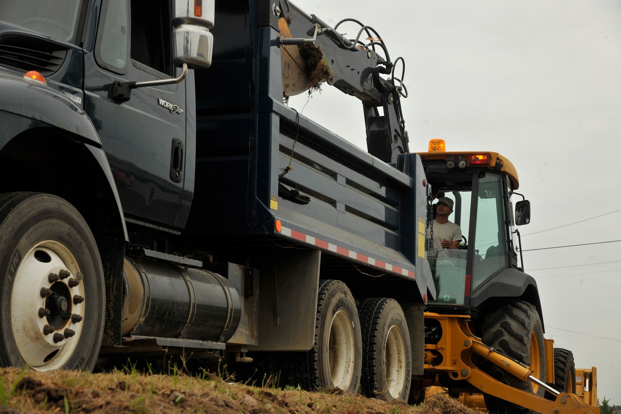 Airman 1st Class Thomas Castaneda, 8th Civil Engineer Squadron pavement and equipment apprentice, dumps dirt from the drainage ditch into a dump truck at Kunsan Air Base, Republic of Korea, June 28, 2012. It takes roughly one to three days to dig out the drainage ditches on each street in preparation for monsoon season. (U.S. Air Force photo/Senior Airman Marcus Morris)