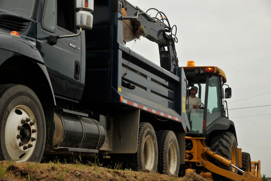 Airman 1st Class Thomas Castaneda, 8th Civil Engineer Squadron pavement and equipment apprentice, dumps dirt from the drainage ditch into a dump truck at Kunsan Air Base, Republic of Korea, June 28, 2012. It takes roughly one to three days to dig out the drainage ditches on each street in preparation for monsoon season. (U.S. Air Force photo/Senior Airman Marcus Morris)