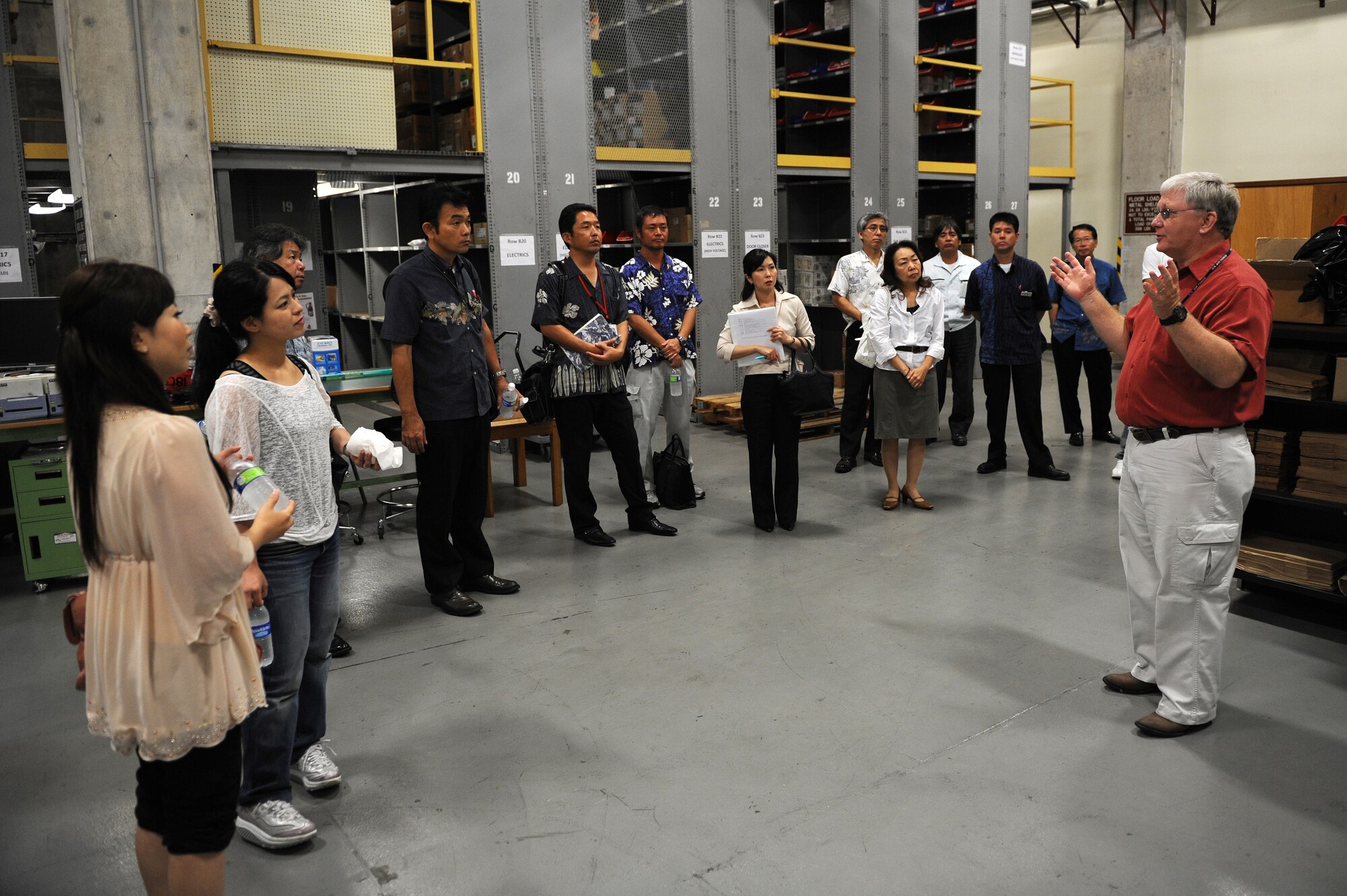 Gary Stout, 18th Civil Engineer Squadron chief of material acquisition, gives a tour of the unit's facility warehouse to local business leaders during the “Okinawa First” business tour on Kadena Air Base, Japan, June 26, 2012. During the tour, Kadena officials explained the base’s purposes and needs to local vendors. They also explained how vendors can get involved, make contact with base points of contact, and conduct business together. The program aims to save the Air Force money while also supporting the local economy. (U.S. Air Force photo/Junko Kinjo)