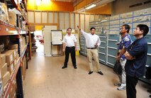 Katsushi Miyagi, 718th Civil Engineer Squadron stock control clerk, gives a tour of the housing warehouse to the local business leaders during the “Okinawa First” business tour on Kadena Air Base, Japan, June 26, 2012. Local Japanese business leaders exchanged business information and discussed base acquisition procedures. The goal of Okinawan First initiative is to save the Air Force money while also supporting the local economy. (U.S. Air Force photo/Junko Kinjo)