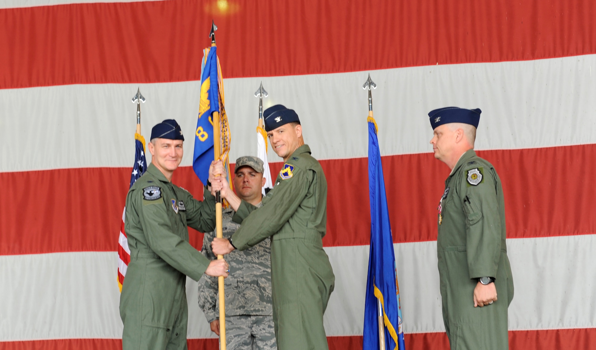 Col. John Pearse, left, 8th Fighter Wing commander, passes the 8th Operations Group guidon to its new commander, Col. James Sturgeon, middle, after Col. Craig Levitt’s one-year tour with the Wolf Pack June 29, 2012, at Kunsan Air Base, Republic of Korea. As the OG commander, Sturgeon is responsible for missions which support armistice and wartime taskings to defend the Republic of Korea. (U.S. Air Force photo/Senior Airman Brigitte N. Brantley)