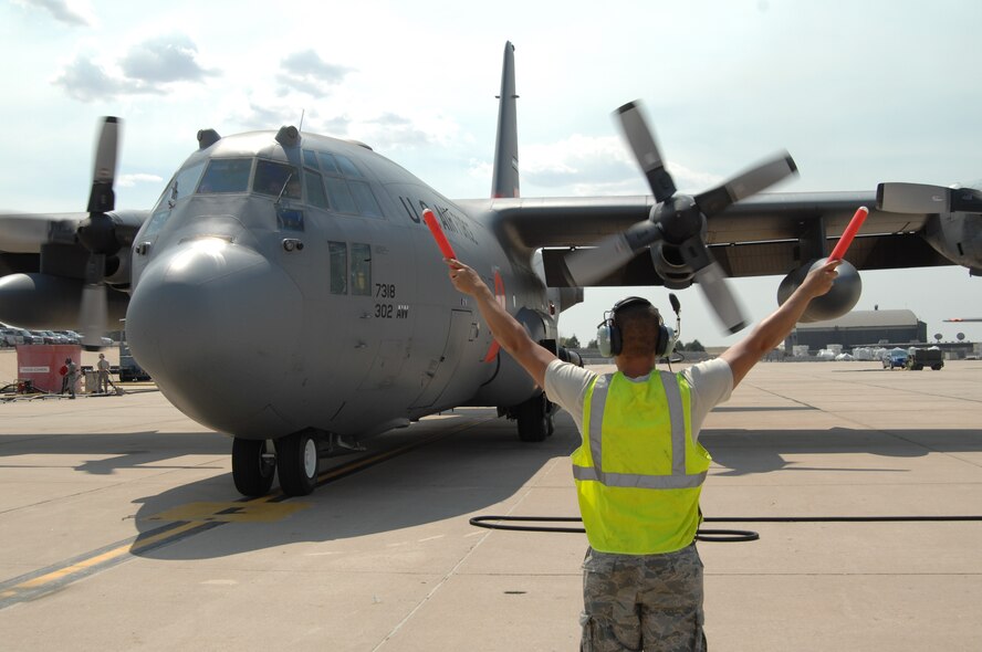 Airman Raymond DeSoto marshals a Modular Airborne Fire Fighting System-equipped C-130 June 29 on the Peterson Air Force Base taxiway in Colorado. MAFFS aircraft from both the 302nd and 153rd Airlift Wings have been supporting Colorado wildland fire fighting efforts since June 25. DeSoto is assigned to the 302nd Aircraft Maintenance Squadron, a subordinate organization to the 302nd AW. (U.S. Air Force photo/Tech. Sgt. Thomas J. Doscher)