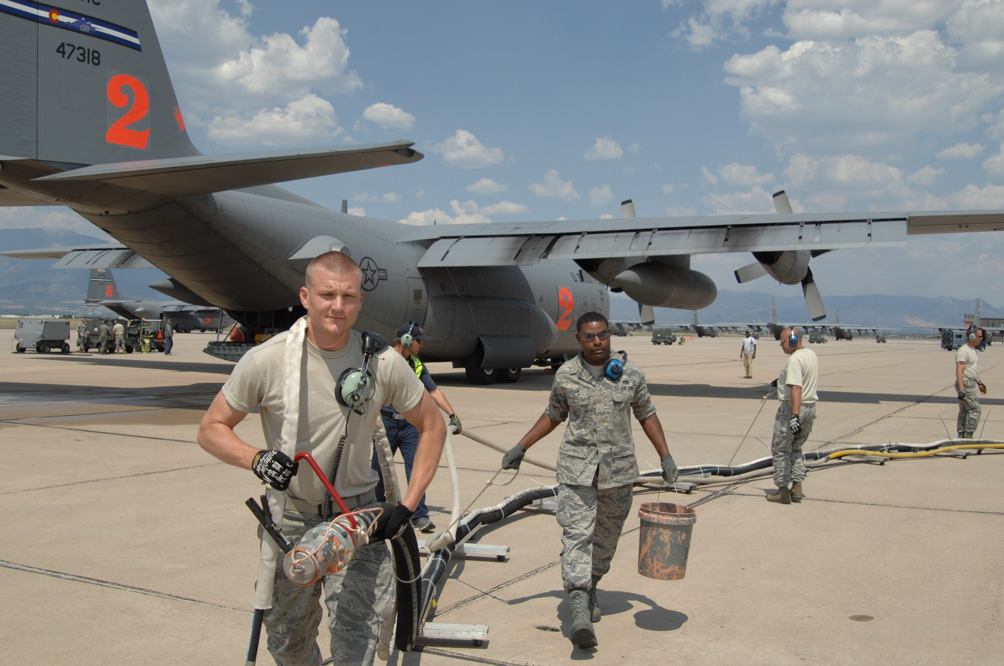 Senior Airmen Dustin Johannsen and Barry Logan pull a retardant hose from a Modular Airborne Fire Fighting System-equipped C-130 preparing to fly a fire retardant drop mission in support of Colorado wildland fire fighting efforts June 29 at Peterson Air Force Base, Colo. MAFFS-equipped aircraft are capable of holding 3,000 gallons of retardant and can disperse it in as little as five seconds. (U.S. Air Force photo/Tech. Sgt. Thomas J. Doscher)