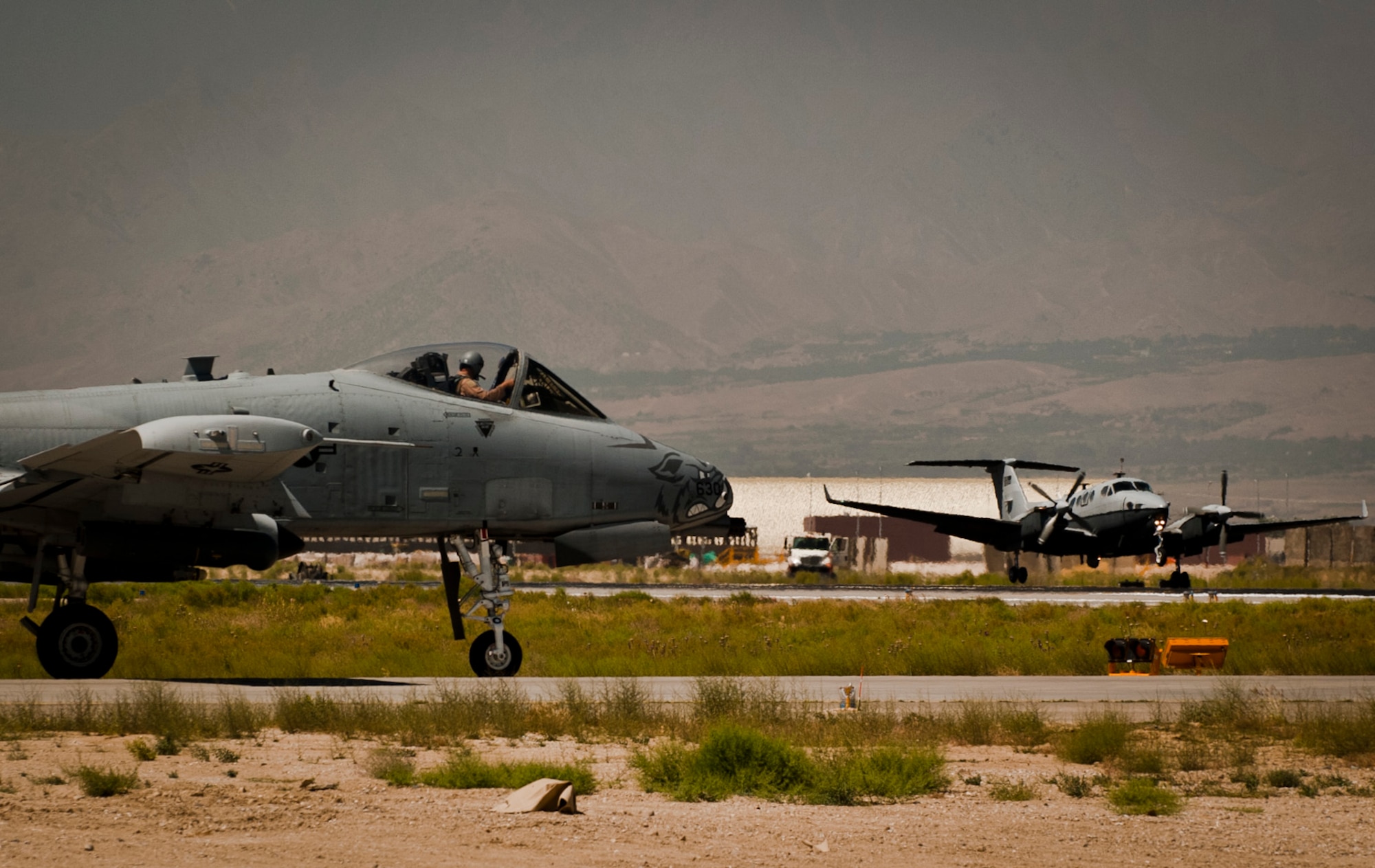 A U.S. Air Force MC-12 Liberty assigned to the 4th Expeditionary Reconnaissance Squadron, flies past a U.S. Air Force A-10 Thunderbolt II assigned to the 104th Expeditionary Fighter Squadron, while landing at Bagram Airfield, Afghanistan, June 28, 2012. The 455th Air Expeditionary Wing’s motto ‘Quaerimus et Perdimus’ (Seek and Destroy) represents its commitment to providing reconnaissance and attack capabilities to coalition ground forces in Afghanistan. (U.S. Air Force photo/Capt. Raymond Geoffroy)