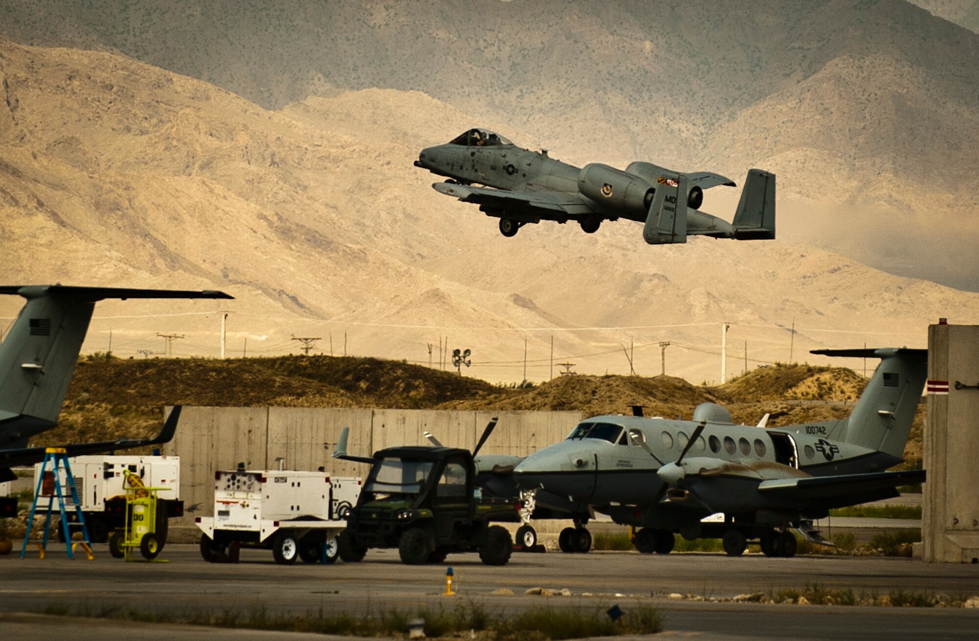 Force A-10 Thunderbolt II assigned to the 104th Expeditionary Fighter Squadron, flies past a U.S. Air Force MC-12 Liberty assigned to the 4th Expeditionary Reconnaissance Squadron, while taking off at Bagram Airfield, Afghanistan, June 28, 2012. The 455th Air Expeditionary Wing’s motto ‘Quaerimus et Perdimus’ (Seek and Destroy) represents its commitment to providing reconnaissance and attack capabilities to coalition ground forces in Afghanistan. (U.S. Air Force photo/Capt. Raymond Geoffroy)