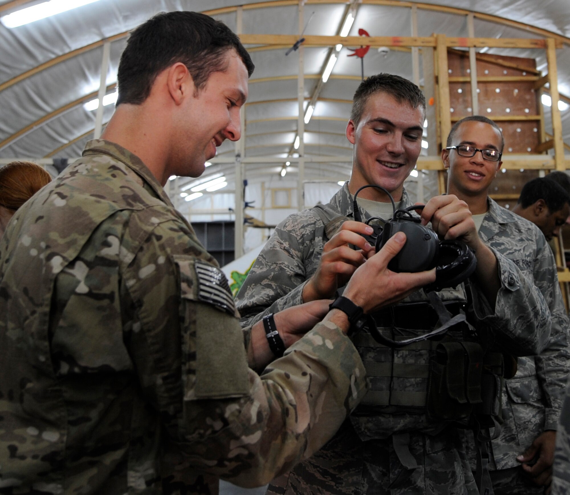 SOUTHWEST ASIA – Staff Sgt. Eric Velazquez, 82nd Expeditionary Air Support Operations Squadron tactical air control party member, helps Cadet 2nd Class Garrett Dean, Air Force Academy cadet, put on equipment during a demonstration June 20. The cadets are here as part of Operation Air Force, a program that sends cadets to deployed locations to help them experience what military life would be like once they graduate and receive their commission. (U.S. Air Force photo/Staff Sgt. Alexandra M. Boutte)