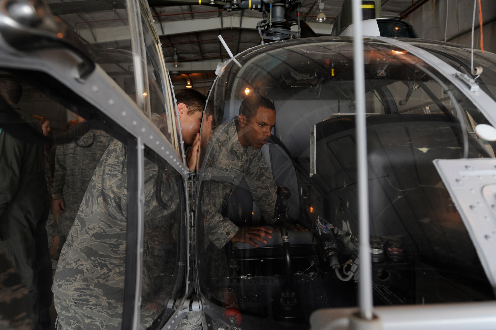 SOUTHWEST ASIA – Nicholas Slater and Kurt Ulrkson, Air Force Academy cadets, look into the cockpit of a helicopter June 20. The cadets were given the opportunity to shadow Airmen in different career fields, interact with officers and enlisted personnel and visit with host nation military members.  (U.S. Air Force photo/Staff Sgt. Alexandra M. Boutte)