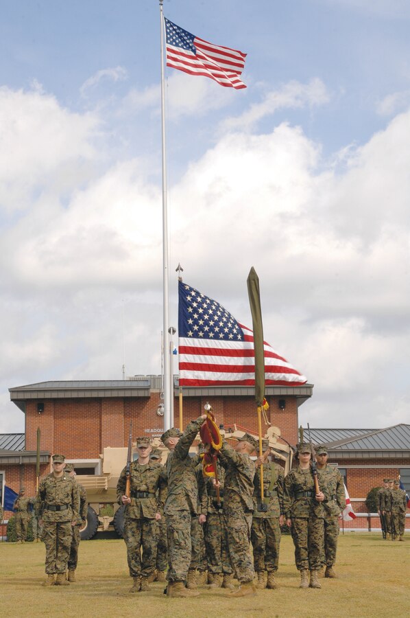 Col. Stephen Medeiros, commander, Marine Depot Maintenance Command, right, and 1st Sgt. Javier Duarte, first sergeant, MDMC, case the colors of Maintenance Center Albany during a deactivation ceremony at Schmid Field, Feb. 23, before their new unit, MDMC, was activated.
