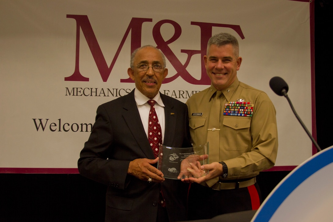 Brigadier Gen. Joseph L. Osterman, commanding general, Marine Corps Recruiting Command, presents the Excellence in Leadership Award to Jerry D. Johnson, a longtime baseball, basketball, football and volleyball official, during the Central Intercollegiate Athletic Association's Hall of Fame breakfast at the Charlotte Convention Center, Mar. 1. The Excellence in Leadership Award is presented to individuals who exhibit the Marine Corps core values honor, courage and commitment in their everyday lives.