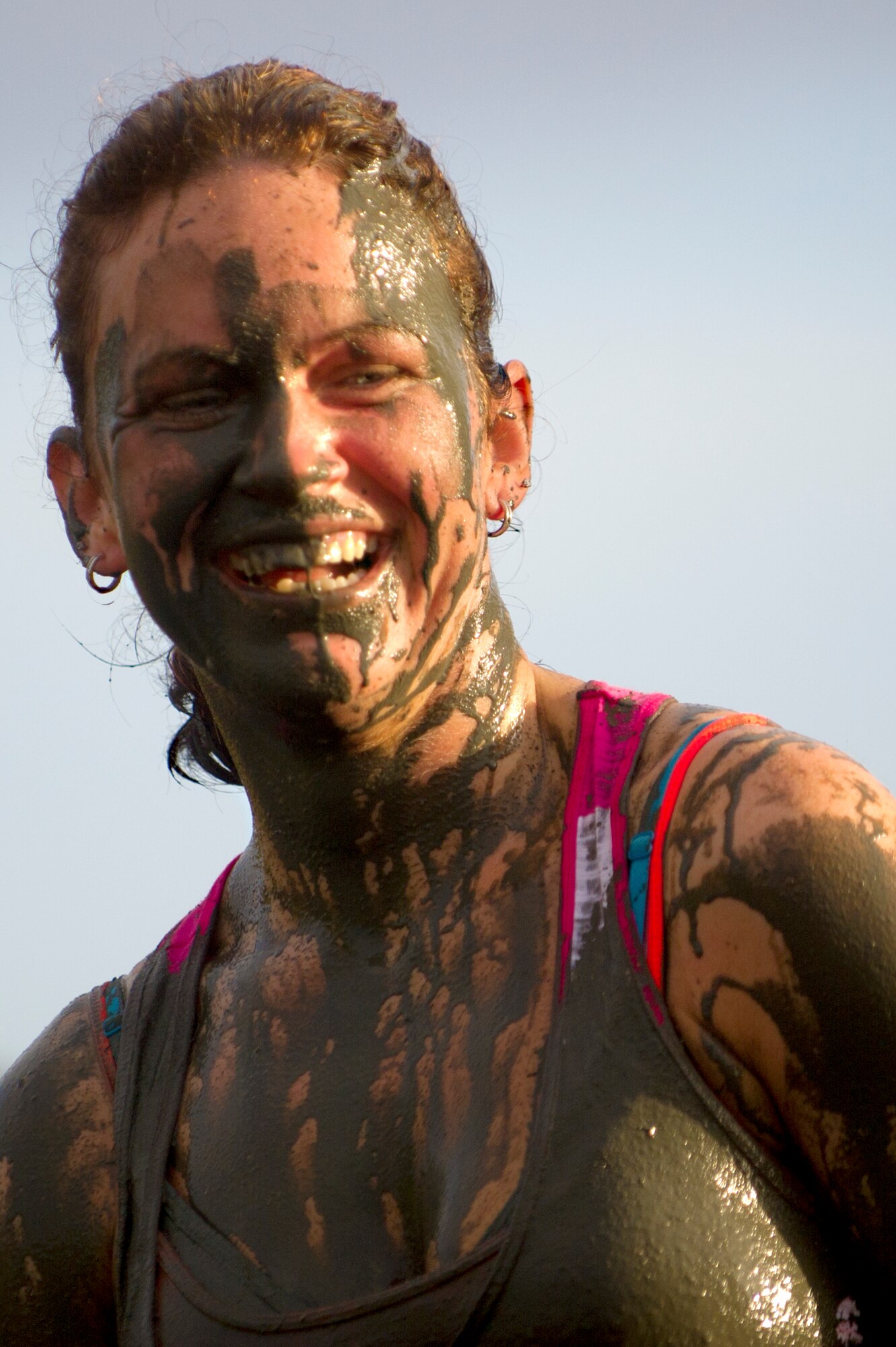 A competitor can only laugh about getting mud in her mouth as she got dirtier than expected while  low crawling through an obstacle during the Swamp Romp, a five-mile run through the mud along the Nu'upia ponds and down the Fort Hase Beach at Marine Corps Base Hawaii - Kaneohe Bay, Feb. 25, 2012. This unique anuual race, known as the "Dirtiest race in Hawaii," takes teams  over and under the challenge-laden course that included unlimited mud, low crawling, jumping, climbing and falling in the mud. (U.S. Air Force photo/Staff Sgt. Mike Meares)