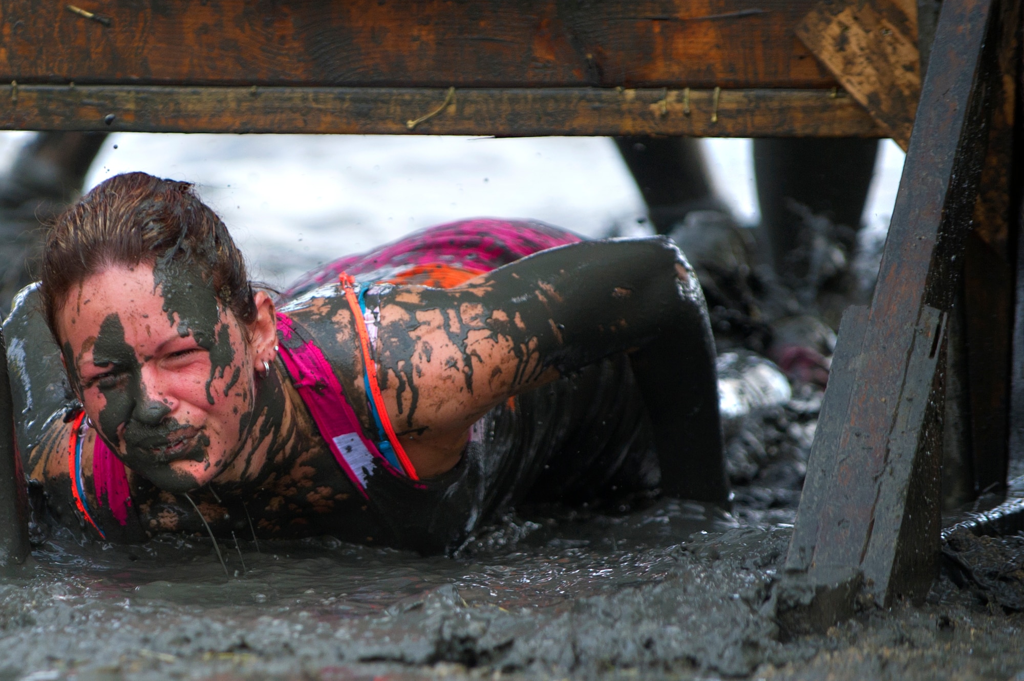 A competitor get dirtier than expected while  low crawling through an obstacle during the Swamp Romp, a five-mile run through the mud along the Nu'upia ponds and down the Fort Hase Beach at Marine Corps Base Hawaii - Kaneohe Bay, Feb. 25, 2012. This unique anuual race, known as the "Dirtiest race in Hawaii," takes teams  over and under the challenge-laden course that included unlimited mud, low crawling, jumping, climbing and falling in the mud. (U.S. Air Force photo/Staff Sgt. Mike Meares)