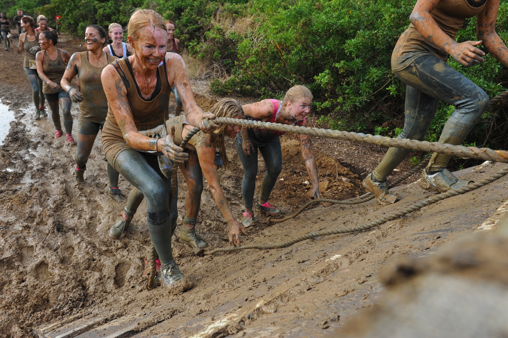 Competitors climb the final obstacle during the Swamp Romp, a five-mile run through the mud along the Nu'upia ponds and down the Fort Hase Beach at Marine Corps Base Hawaii - Kaneohe Bay, Feb. 25, 2012. This unique run, known as the "Dirtiest race in Hawaii" takes teams  over and under the challenge-laden course that included unlimited mud, low crawling, jumping, climbing and falling in the mud. (U.S. Air Force photo/Staff Sgt. Mike Meares)