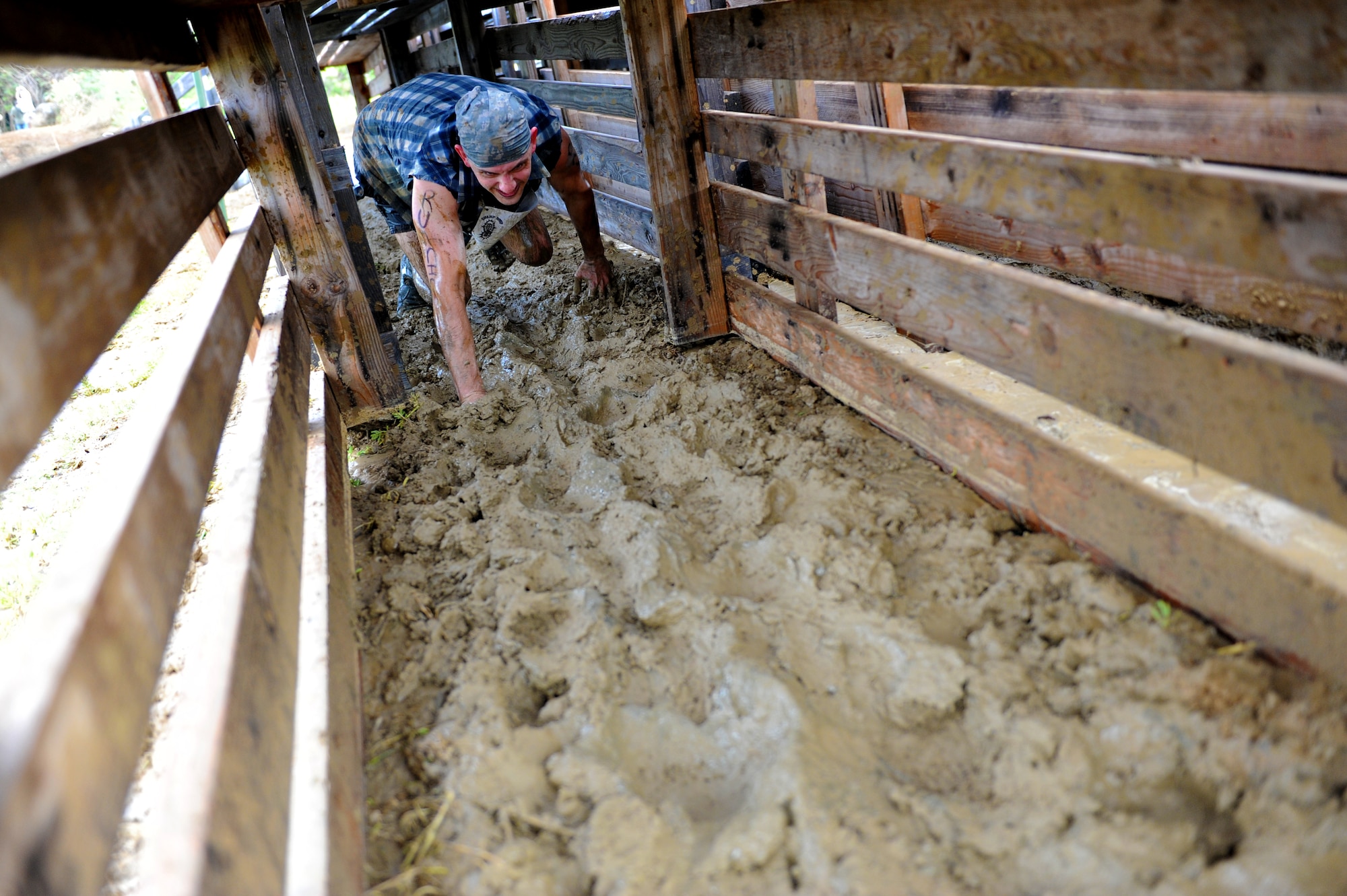 There was only one way through the chute as competitors were forced to crawl during an obstacle at the Swamp Romp, a five-mile run through the mud along the Nu'upia ponds and down the Fort Hase Beach at Marine Corps Base Hawaii - Kaneohe Bay, Feb. 25, 2012. This unique run, known as the "Dirtiest race in Hawaii" takes teams  over and under the challenge-laden course that included unlimited mud, low crawling, jumping, climbing and falling in the mud. (U.S. Air Force photo/Staff Sgt. Mike Meares)