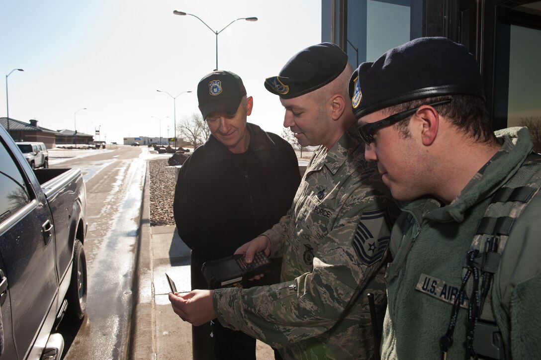 Senior Master Sgt. Eric, 28th Security Forces Squadron operations superintendent, trains Officer Ken Flood and Airman 1st Class Philip Pamer, 28th SFS installation entry controllers, on the Defense Biometric Identification System at the Liberty Gate on Ellsworth Air Force Base, S.D., Feb. 29, 2012. Entry controllers scan identification cards using DBIDS which immediately reports if an individual is authorized entry to the base. (U.S. Air Force photo by Airman 1st Class Kate Thornton/Released)