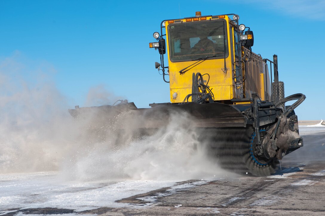 Jim Mastin, 28th Civil Engineer Squadron heavy equipment operator, operates a snow sweeper to clear snow from the runway at Ellsworth Air Force Base, S.D., Feb. 29, 2012. Snow is removed so Airmen can identify runway signs and see any potentially damaging foreign objects. (U.S. Air Force photo by Airman 1st Class Zachary Hada/Released)