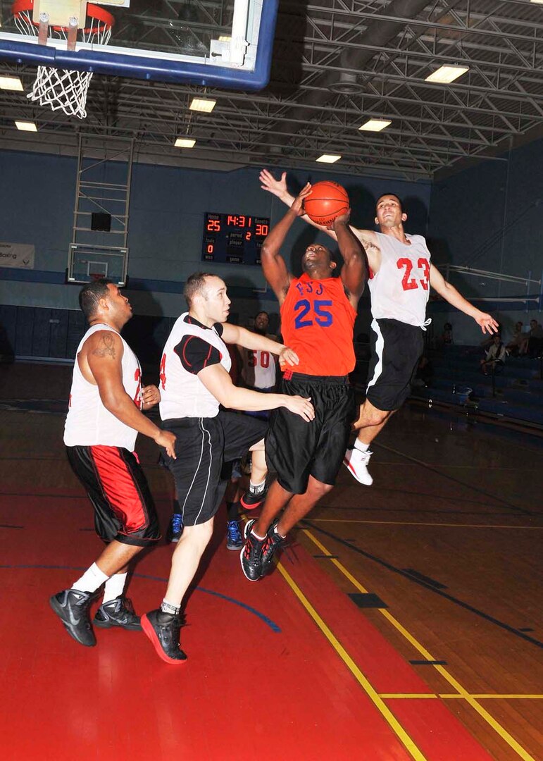 802nd Force Support Squadron guard Christian Torres goes airborne as 543rd Support Squadron’s Kevin Crider attempts to block the shot during the Division I intramural basketball season finale Feb. 28 at Joint Base San Antonio-Lackland, Texas. (U.S. Air Force photo/Alan Boedeker)