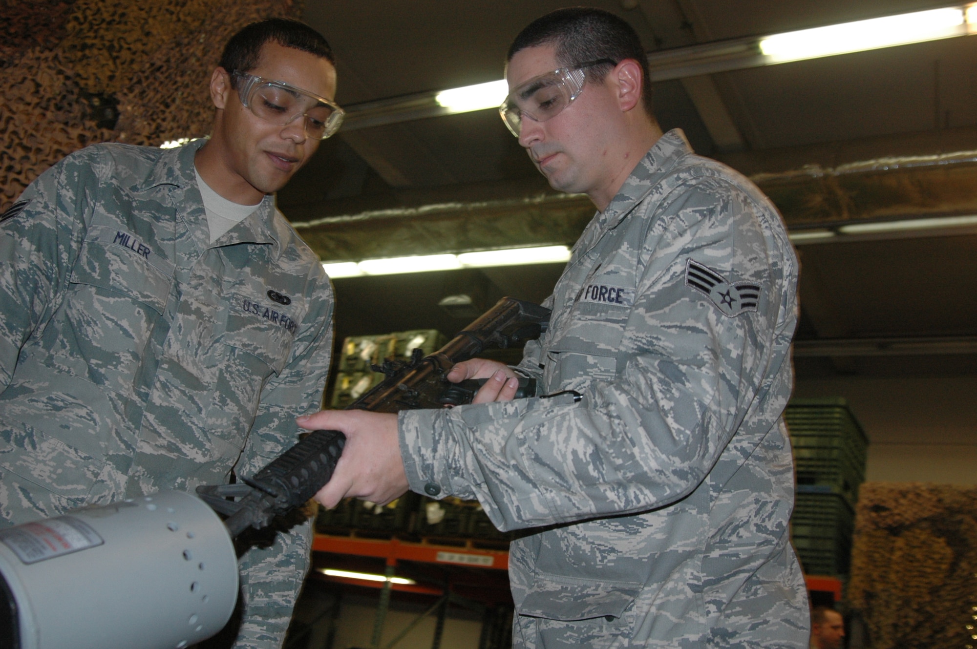 Senior Airman Birce Miller, 60th Logistics Readiness Individual Protective Equipment warehouse technician attends as Senior Airman Andrew Primas, 60th LRS IPE weapons vault technician clears a weapon of ammunition, Feb. 24, at the IPE facility. (U.S. Air Force photo/Tyler Grimes)