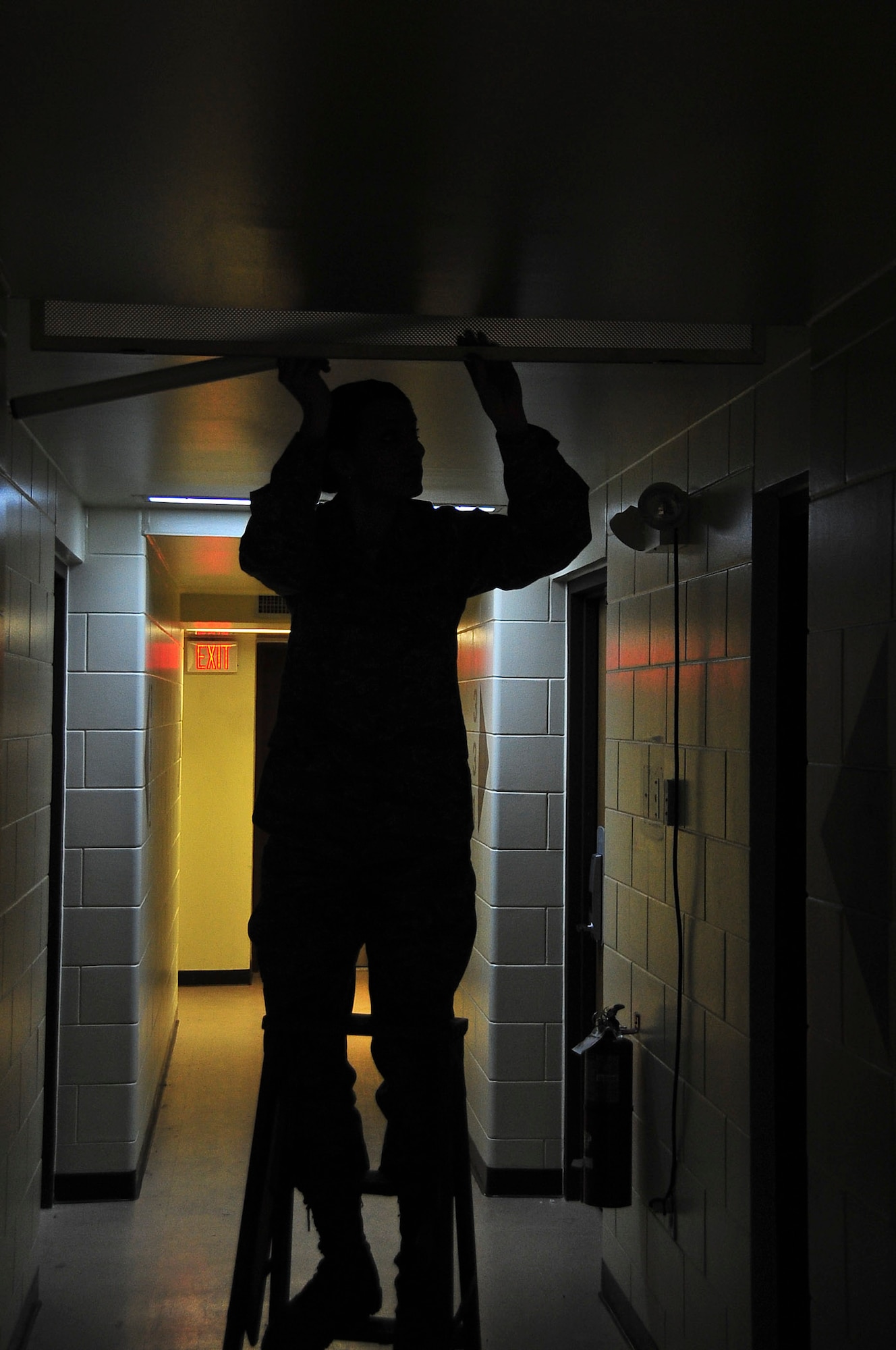 Staff Sgt. Amber Capello, 51st Civil Engineer Squadron Airman dorm leader, changes out a light fixture in a hallway here, Feb. 29, 2012. Sergeant Capello is responsible for dormitories which house 192 residents. (U.S. Air Force photo/Senior Airman Adam Grant)