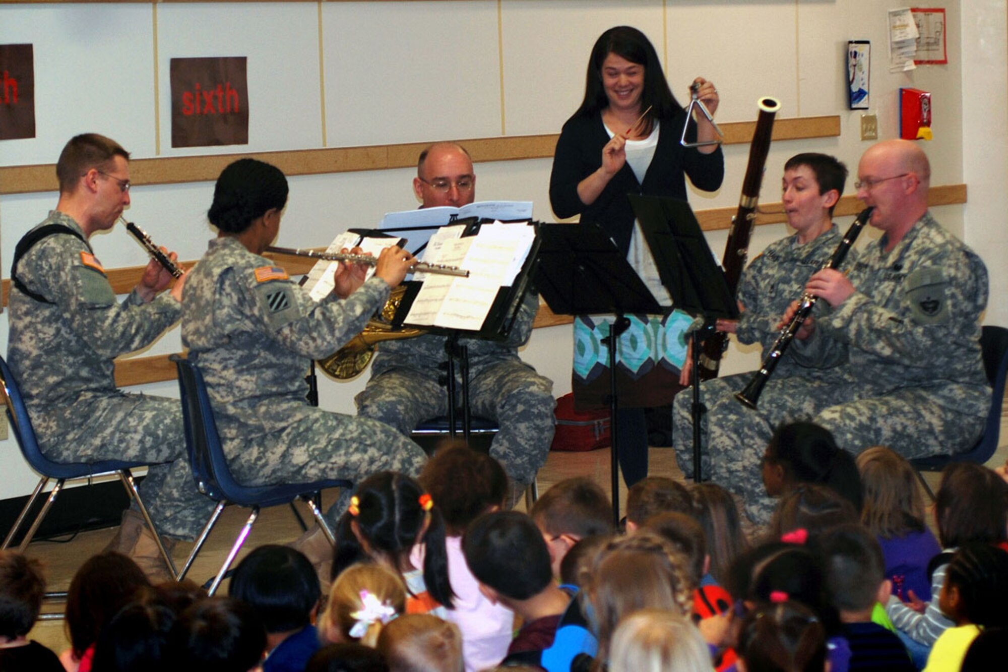 Lori Doyle, a substitute teacher at Ursa Major Elementary School on Joint Base Elmendorf-Richardson, plays the triangle as a surprise guest performer with members of the 9th Army Band during U.S. Army Alaska’s observance of Music in Our Schools
month. (U.S. Army photo/Staff Sgt. Matthew E. Winstead)
