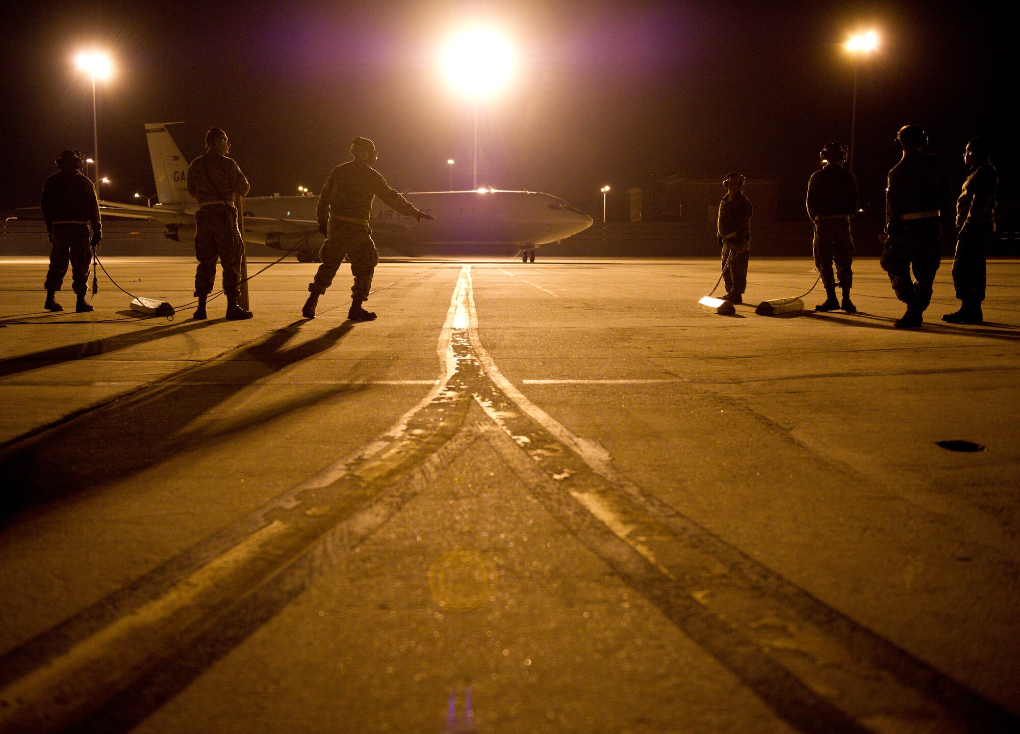 Crew chiefs from the 116th and 461st Air Control Wings catch an E-8 Joint STARS returning from a night mission at Robins Air Force Base, Ga., Feb. 15, 2012. The crew chiefs wait as the aircraft is marshaled to its parking spot so they can perform post-flight checks and ensure the aircraft is ready for its next mission.  (National Guard photo by Master Sgt. Roger Parsons/Released)