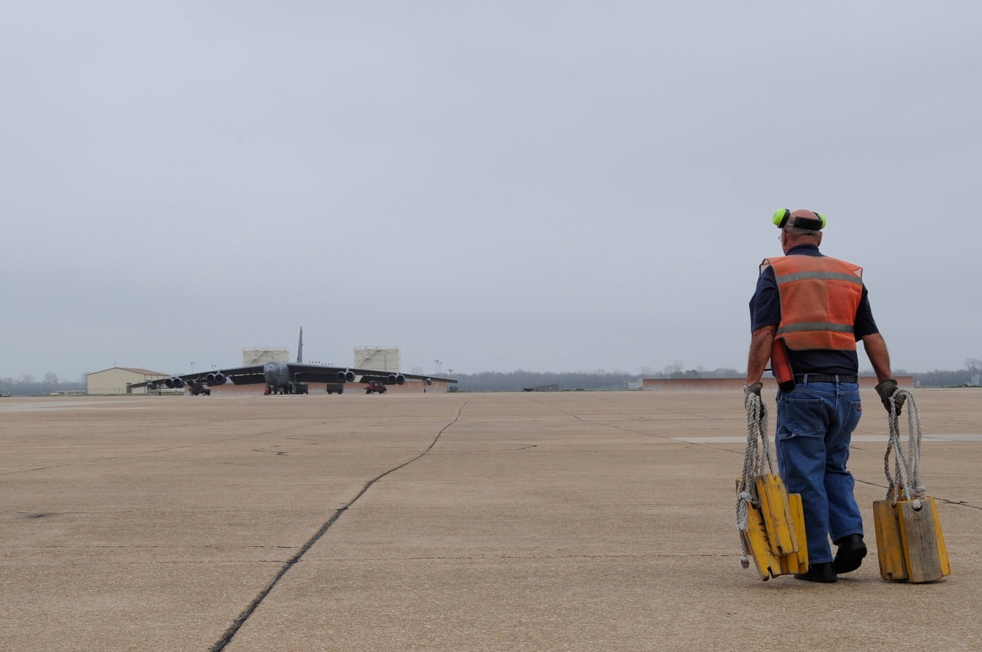 Retired Master Sgt. Ted Trujillo, 2nd Bomb Wing Transient Alert unit, carries chalks onto the flightline on Barksdale Air Force Base, La., Feb. 28. In order for an aircraft to stay stationary while parked, chalks are placed around each wheel. (U.S. Air Force photo/Airman 1st Class Benjamin Gonsier)(RELEASED)