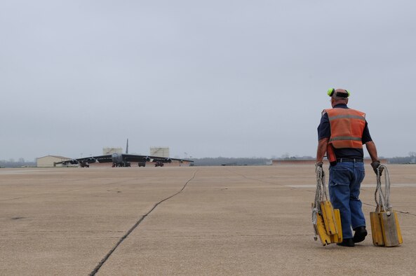 Retired Master Sgt. Ted Trujillo, 2nd Bomb Wing Transient Alert unit, carries chalks onto the flightline on Barksdale Air Force Base, La., Feb. 28. In order for an aircraft to stay stationary while parked, chalks are placed around each wheel. (U.S. Air Force photo/Airman 1st Class Benjamin Gonsier)(RELEASED)