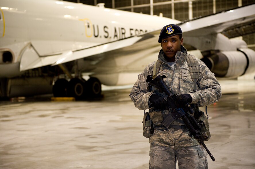 U.S. Air Force Airman 1st Class Jonathan Harris, 78th Security Forces Squadron, stands guard beside an  E-8 Joint STARS at Robins Air Force Base, Ga., Feb. 15, 2012.  Harris provided security while the aircraft was in the hangar for maintenance.  (National Guard photo by Master Sgt. Roger Parsons/Released)