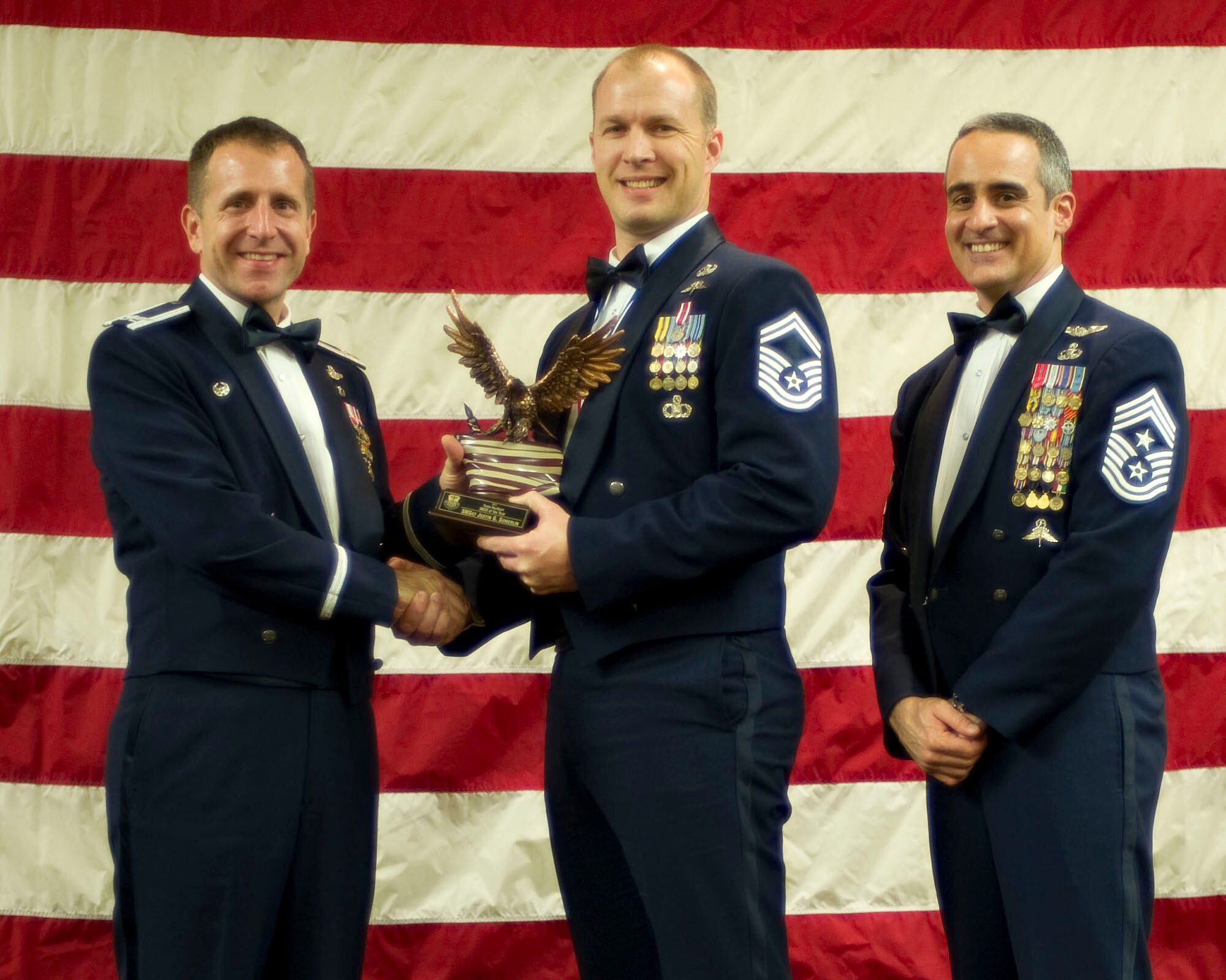 Col. Jim Slife, commander of the 1st Special Operations Wing, left, and Chief Master Sgt. Ramon Colon-Lopez, command chief of the 1st SOW, right, present Senior Master Sgt. Justin Sumerlin, Air Force Special Operations Command, center, with the Team Hurlburt Senior NCO of the Year award at the 2011 Team Hurlburt Annual Awards Banquet at the Soundside Club at Hurlburt Field, Fla., Feb. 24, 2012. (U.S. Air Force photo by Airman 1st Class Gustavo Castillo) (Released) 