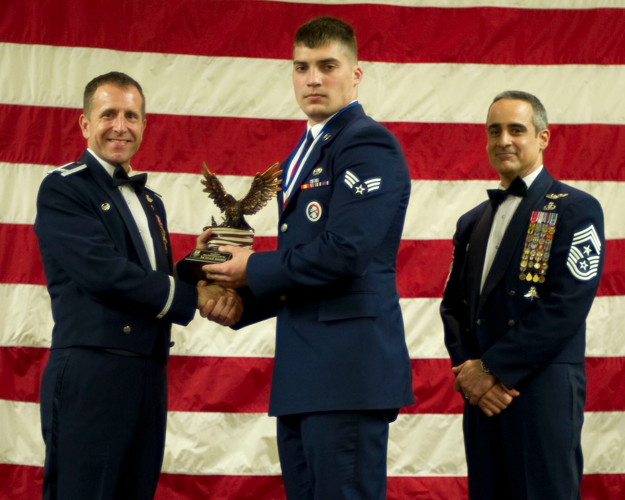 Col. Jim Slife, commander of the 1st Special Operations Wing, left, and Chief Master Sgt. Ramon Colon-Lopez, command chief of the 1st SOW, right, present Senior Airman Taylor Gardenour, 1st Special Operations Component Maintenance Squadron, center, with the Team Hurlburt Ceremonial Guardsman of the Year award at the 2011 Team Hurlburt Annual Awards Banquet at the Soundside Club at Hurlburt Field, Fla., Feb. 24, 2012. (U.S. Air Force photo by Airman 1st Class Gustavo Castillo) (Released) 
