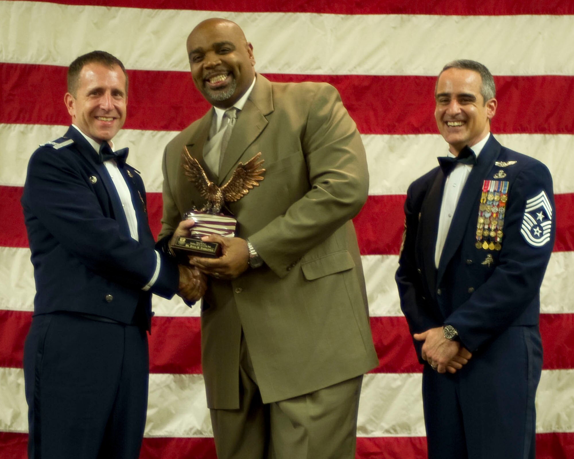 Col. Jim Slife, commander of the 1st Special Operations Wing, left, and Chief Master Sgt. Ramon Colon-Lopez, command chief of the 1st SOW, right, present Byron Stubblefield, 1st Special Operations Support Squadron, center, with the Team Hurlburt GS 9-12 Civilian of the Year award at the 2011 Team Hurlburt Annual Awards Banquet at the Soundside Club at Hurlburt Field, Fla., Feb. 24, 2012. (U.S. Air Force photo by Airman 1st Class Gustavo Castillo) (Released) 