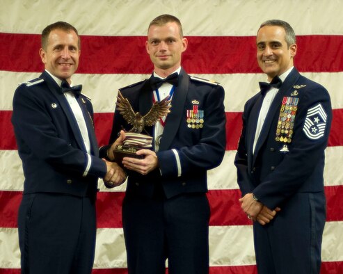 Col. Jim Slife, commander of the 1st Special Operations Wing, left, and Chief Master Sgt. Ramon Colon-Lopez, command chief of the 1st SOW, right, present Maj. Patrick Kolesiak, Air Force Special Operations Command, center, with the Team Hurlburt Field Grade Officer of the Year award at the 2011 Team Hurlburt Annual Awards Banquet at the Soundside Club at Hurlburt Field, Fla., Feb. 24, 2012. (U.S. Air Force photo by Airman 1st Class Gustavo Castillo) (Released) 