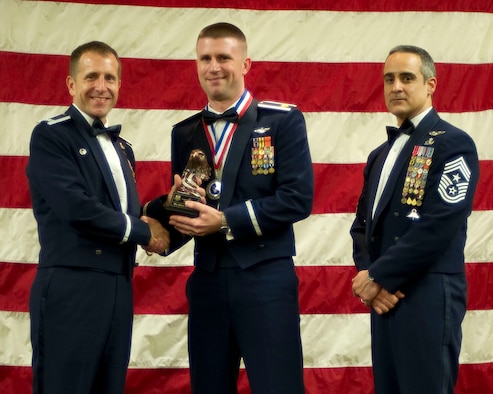 Col. Jim Slife, commander of the 1st Special Operations Wing, left, and Chief Master Sgt. Ramon Colon-Lopez, command chief of the 1st SOW, right, present Maj. Joshua Petry, 15th Special Operations Squadron, center, with the 1st SOW Field Grade Officer of the Year award at the 2011 Team Hurlburt Annual Awards Banquet at the Soundside Club at Hurlburt Field, Fla., Feb. 24, 2012. (U.S. Air Force photo by Airman 1st Class Gustavo Castillo) (Released) 