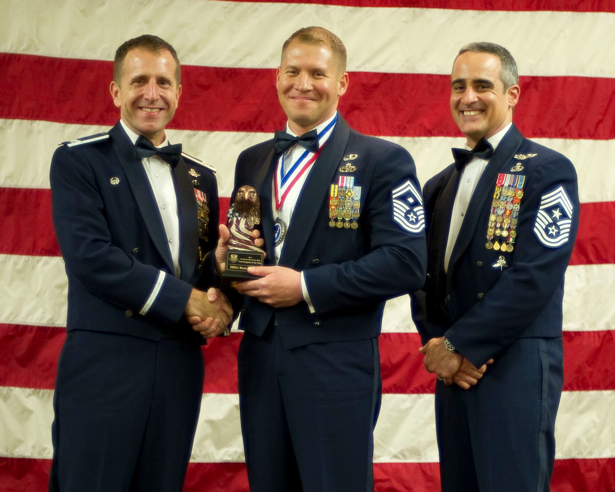 Col. Jim Slife, commander of the 1st Special Operations Wing, left, and Chief Master Sgt. Ramon Colon-Lopez, command chief of the 1st SOW, right, present Senior Master Sgt. Brian Stone, first sergeant of the 4th Special Operations Squadron, center, with the 1st SOW First Sergeant of the Year award at the 2011 Team Hurlburt Annual Awards Banquet at the Soundside Club at Hurlburt Field, Fla., Feb. 24, 2012. (U.S. Air Force photo by Airman 1st Class Gustavo Castillo) (Released) 