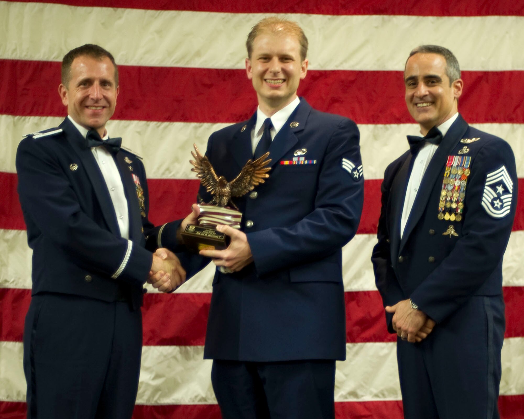 Col. Jim Slife, commander of the 1st Special Operations Wing, left, and Chief Master Sgt. Ramon Colon-Lopez, command chief of the 1st SOW, right, present Senior Airman Joe McFadden, a public affairs specialist from the 1st SOW, center, with the Team Hurlburt Airman of the Year award at the 2011 Team Hurlburt Annual Awards Banquet at the Soundside Club at Hurlburt Field, Fla., Feb. 24, 2012. (U.S. Air Force photo by Airman 1st Class Gustavo Castillo) (Released) 