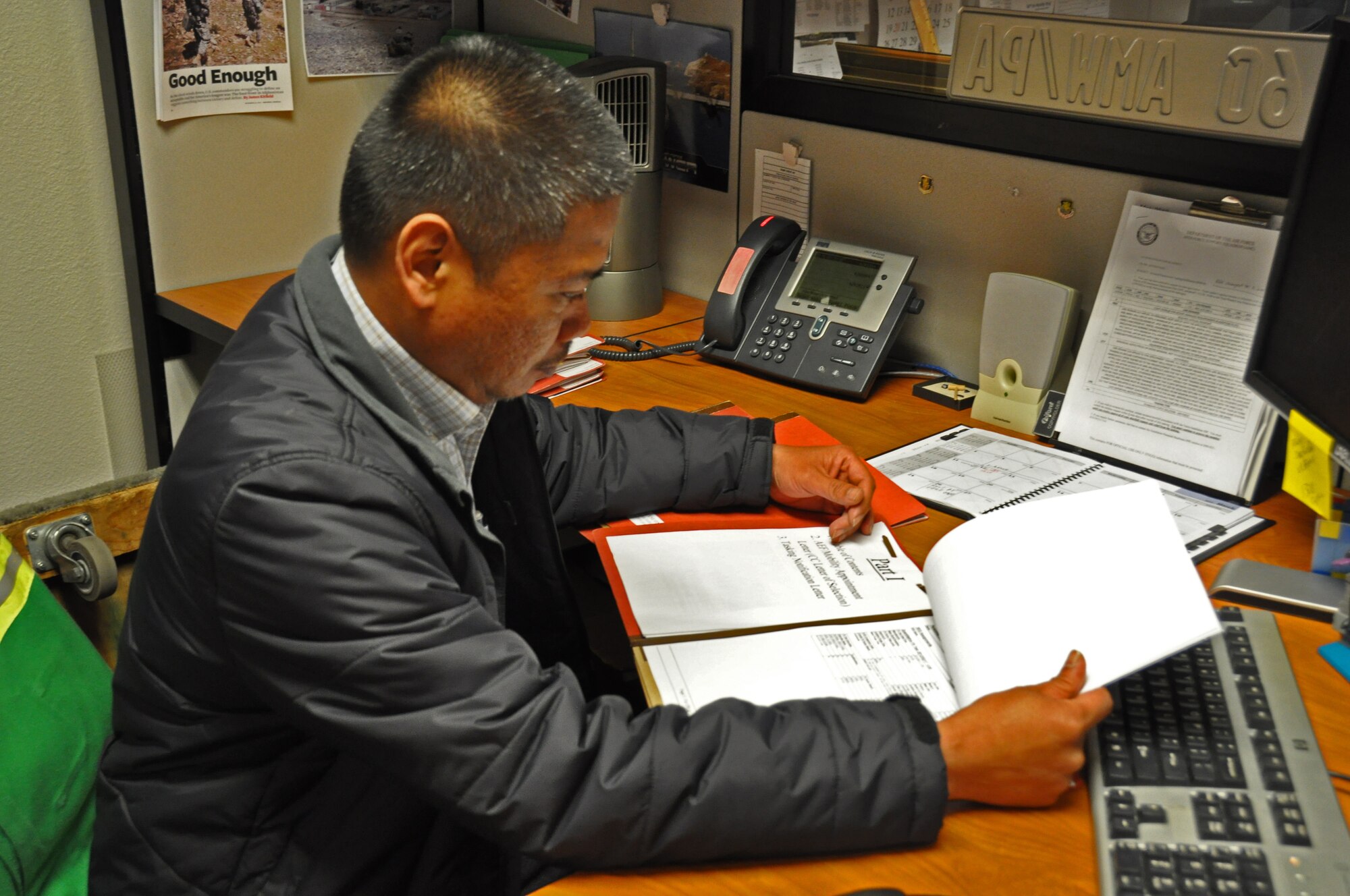 Erwin Barrientos, 60th Air Mobility Wing Director of Staff unit deployment manager, reviews mobility folders Wednesday to ensure Airmen are prepared for deployment. (U.S. Air Force photo/Airman 1st Class Madelyn Ottem)