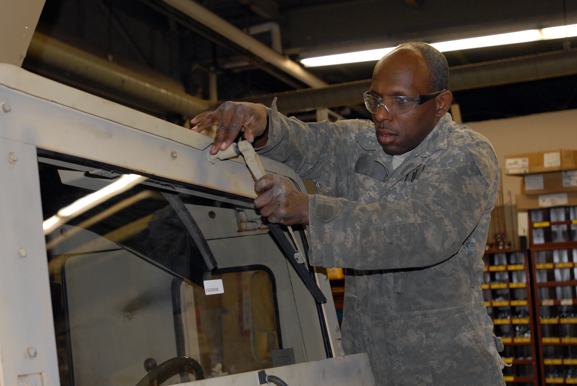 Staff Sgt. Anthony Christy, a vehicle mechanic with the 1st Logistic Support Battalion, 322nd Regiment, 72nd Field Artillery Brigade, reattaches a windshield wiper on a vehicle after replacing the windshield. (U.S. Army photo by Staff Sgt. Nicole Dykstra/Released)